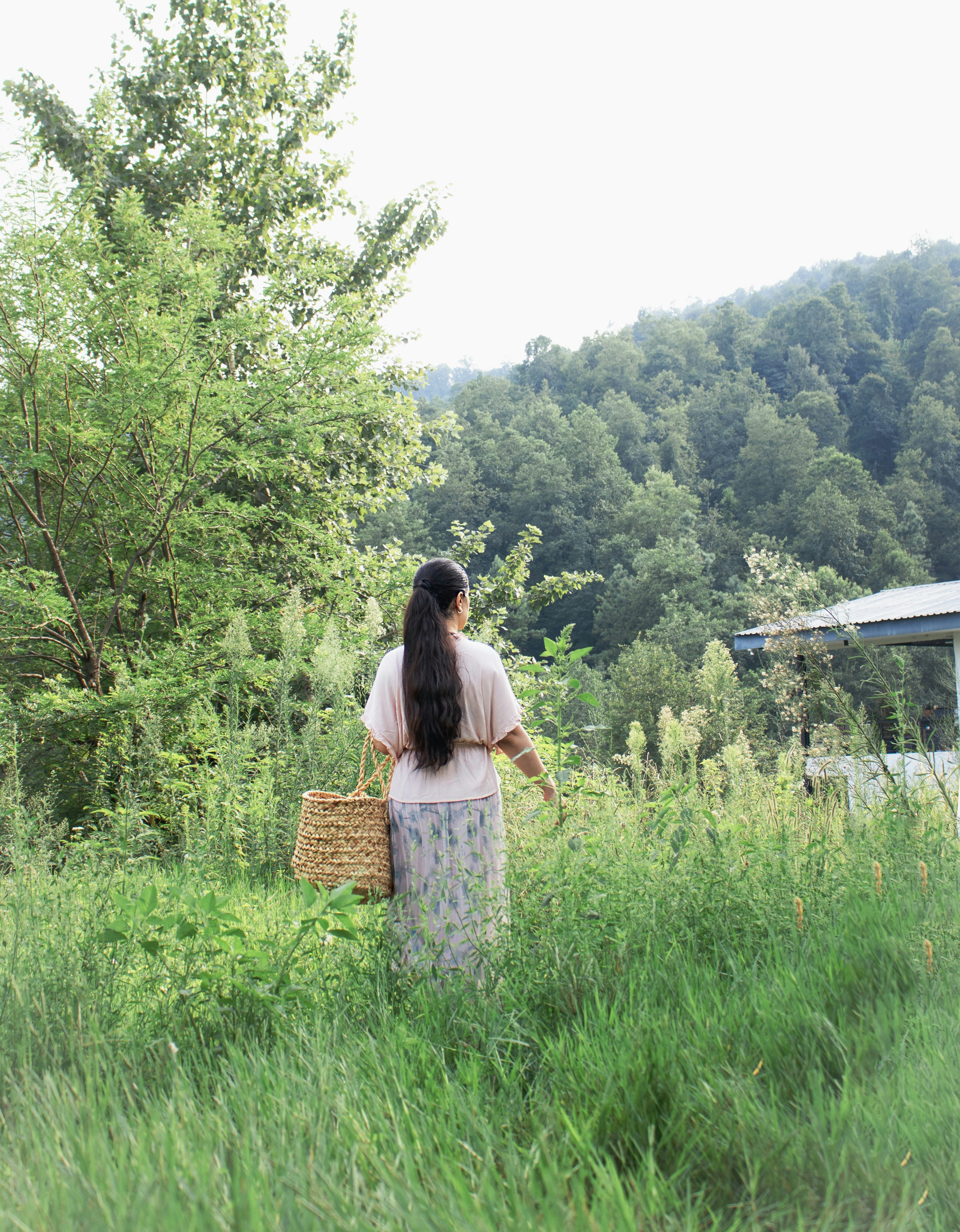 A woman walking through a lush green field