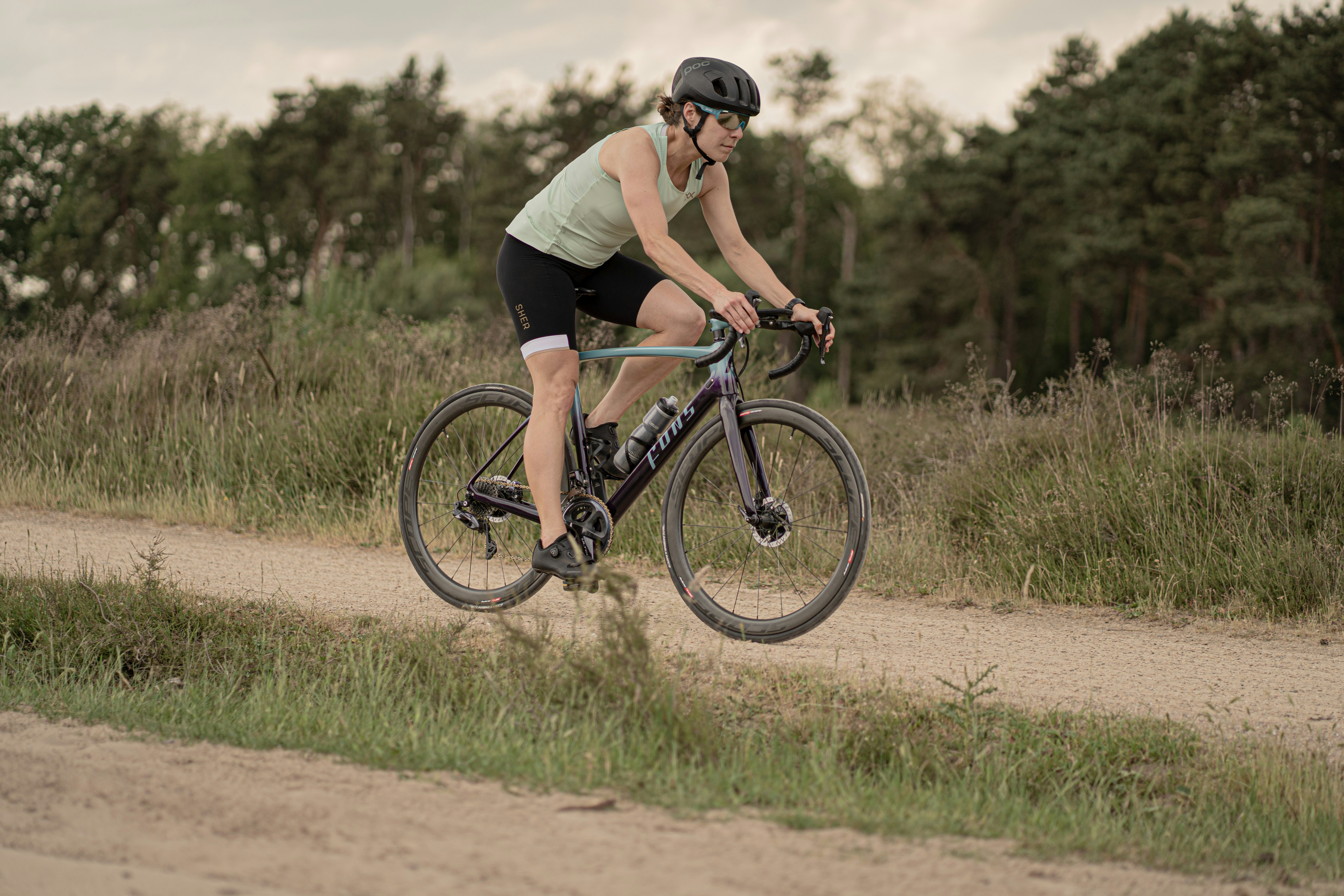 A man riding a bike down a dirt road