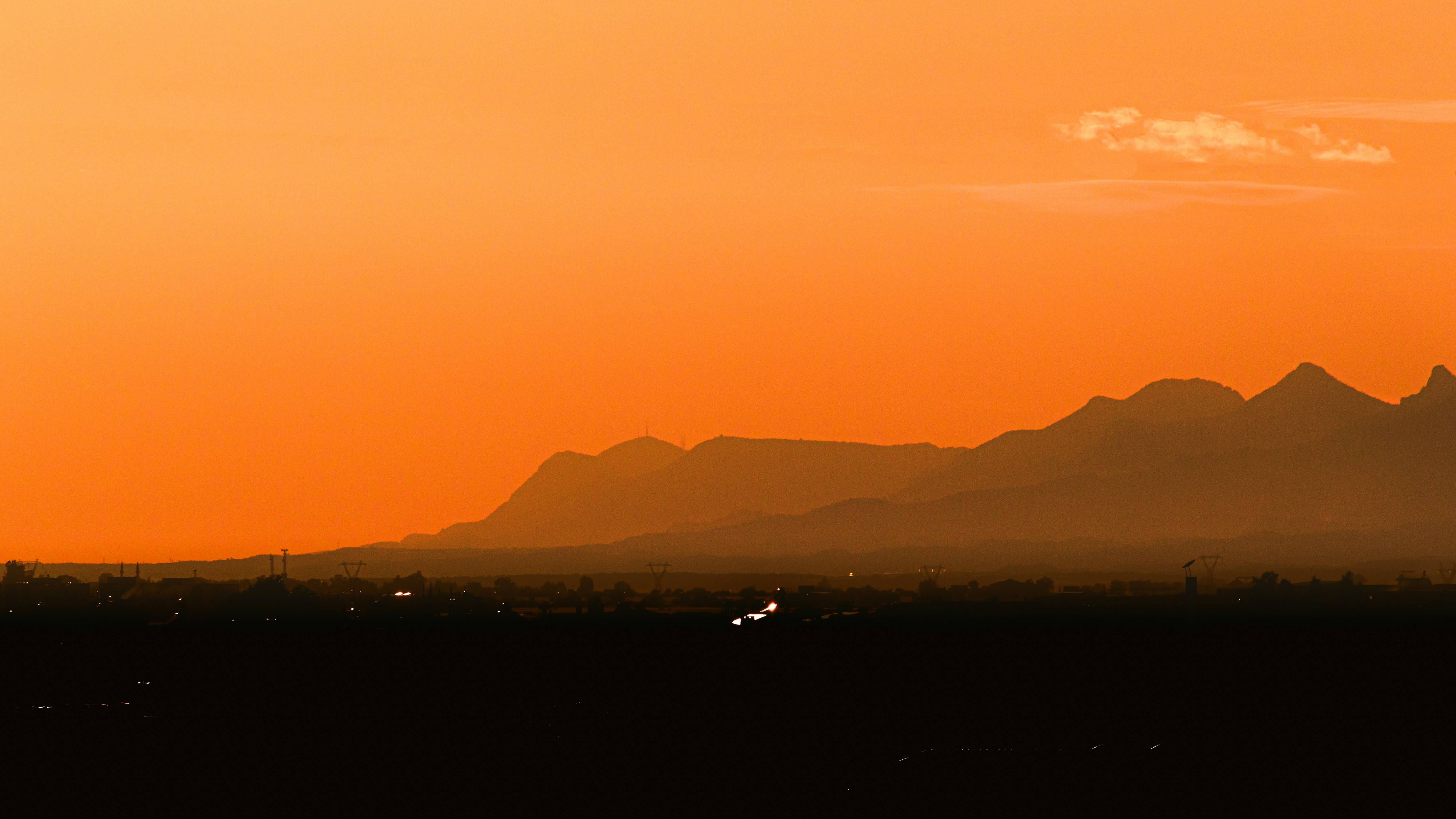 A plane flying in the sky with a mountain in the background