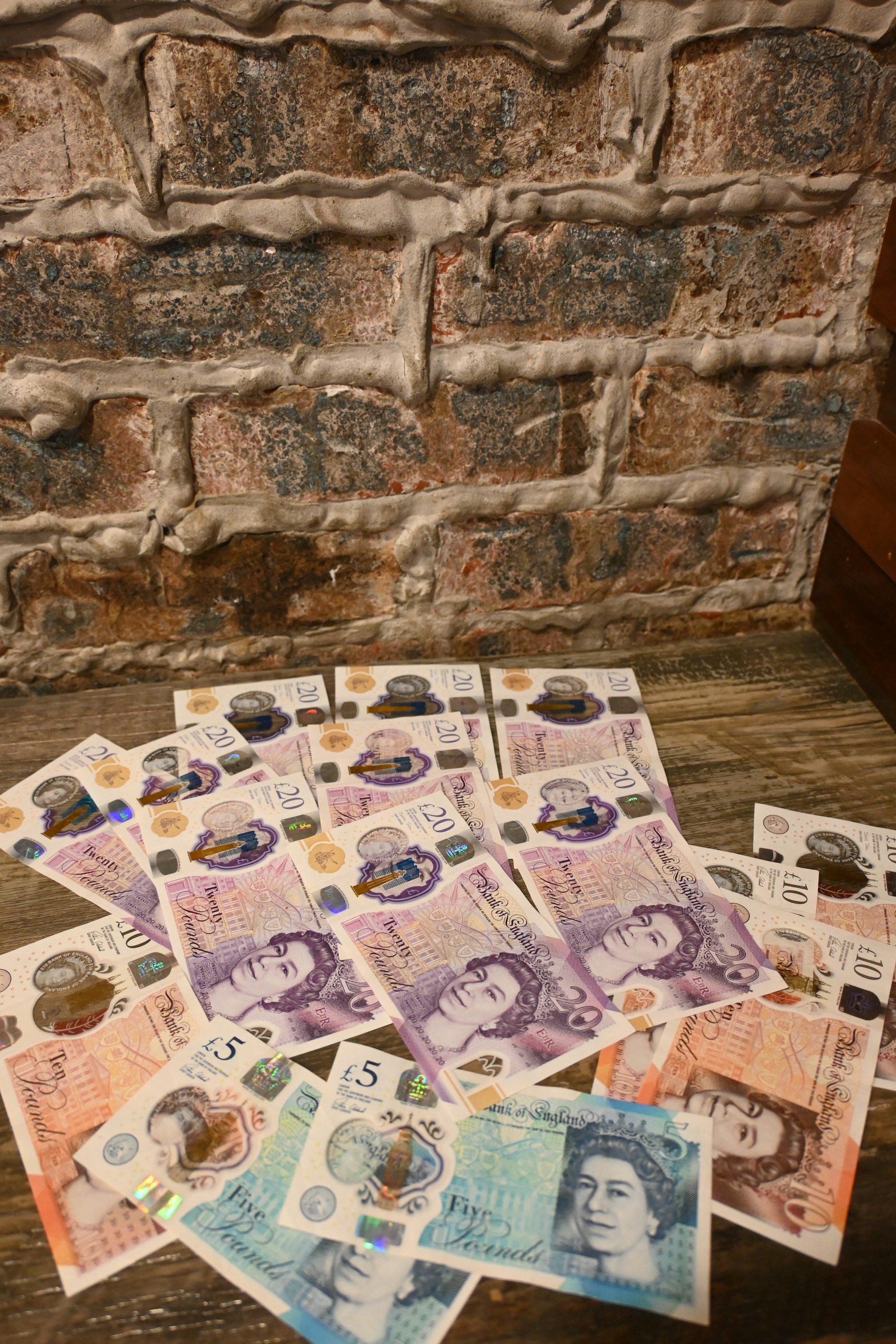 A pile of foreign currency sitting on top of a wooden table