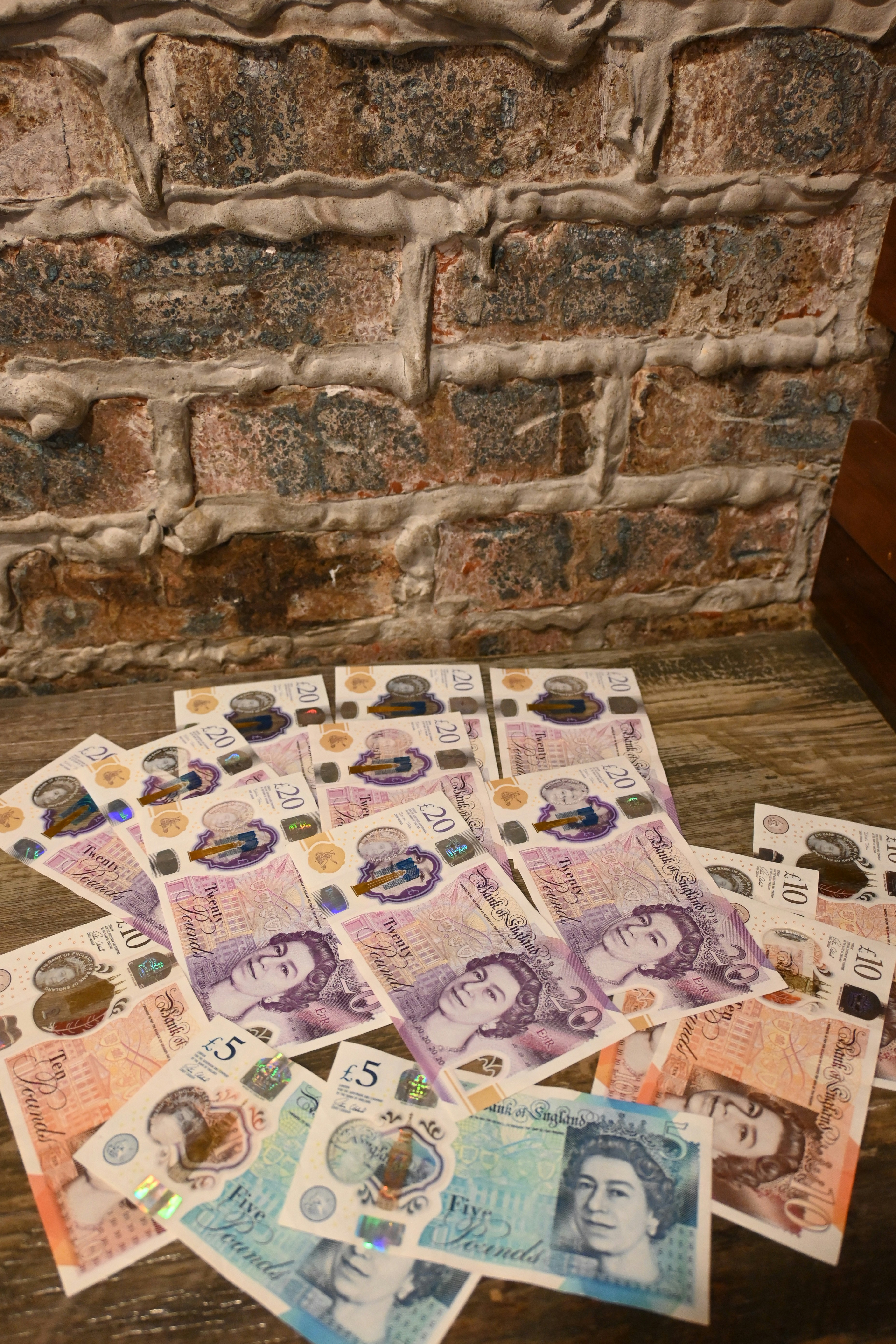 A pile of foreign currency sitting on top of a wooden table