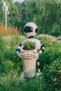 A robot holding a potted plant in a field