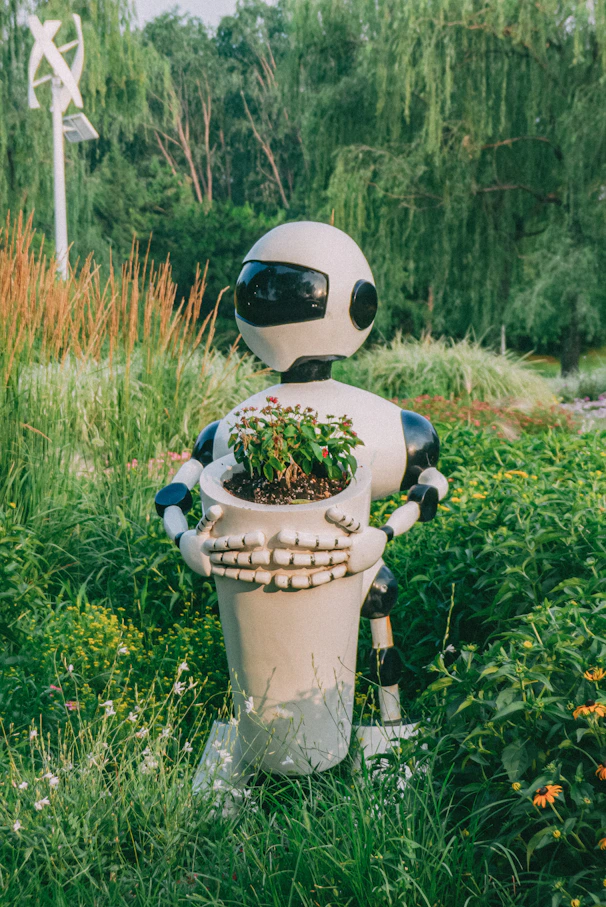 A robot holding a potted plant in a field
