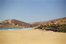 A sandy beach with a mountain in the background
