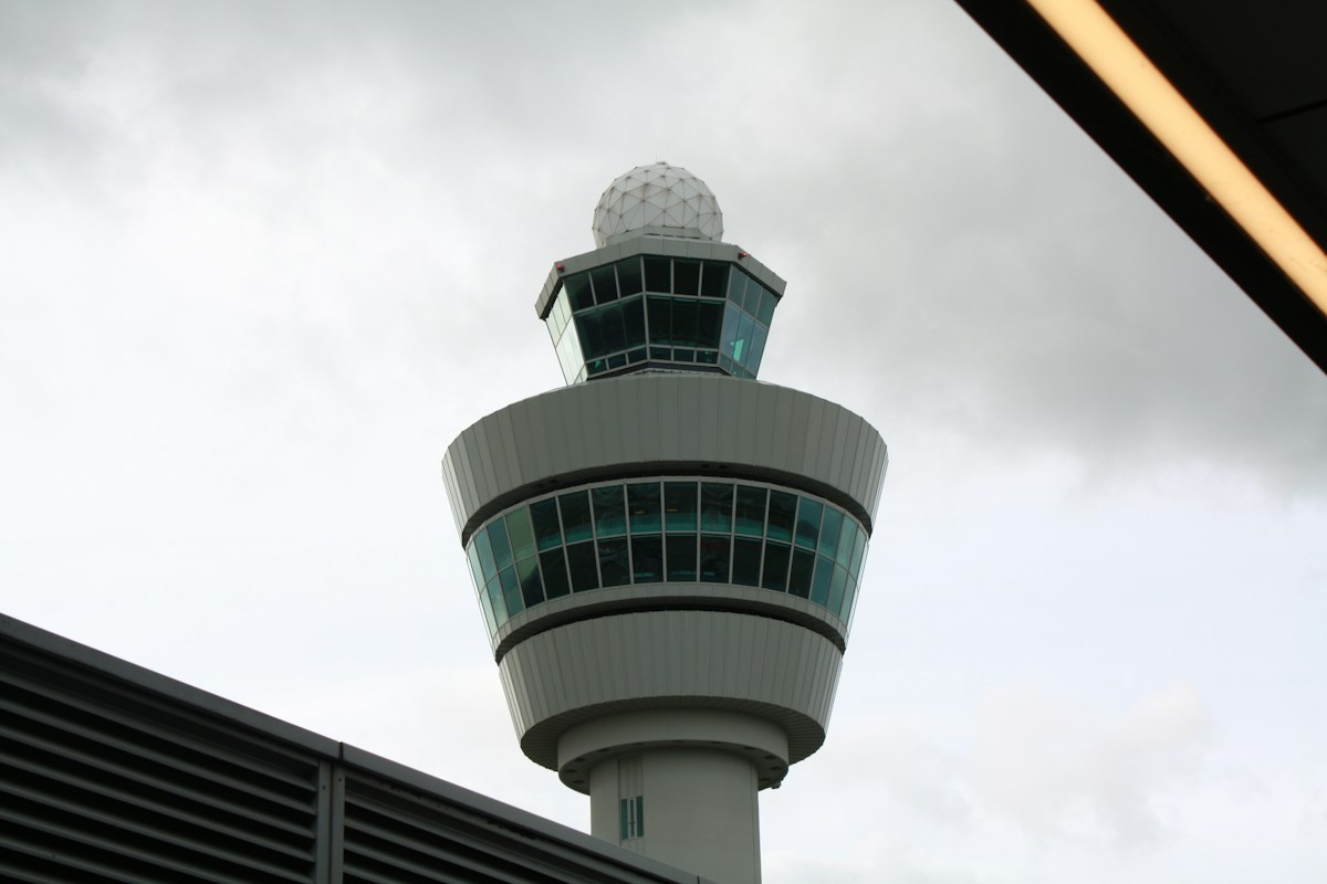 An airport control tower against an overcast sky, representing mission and critical infrastructure environments