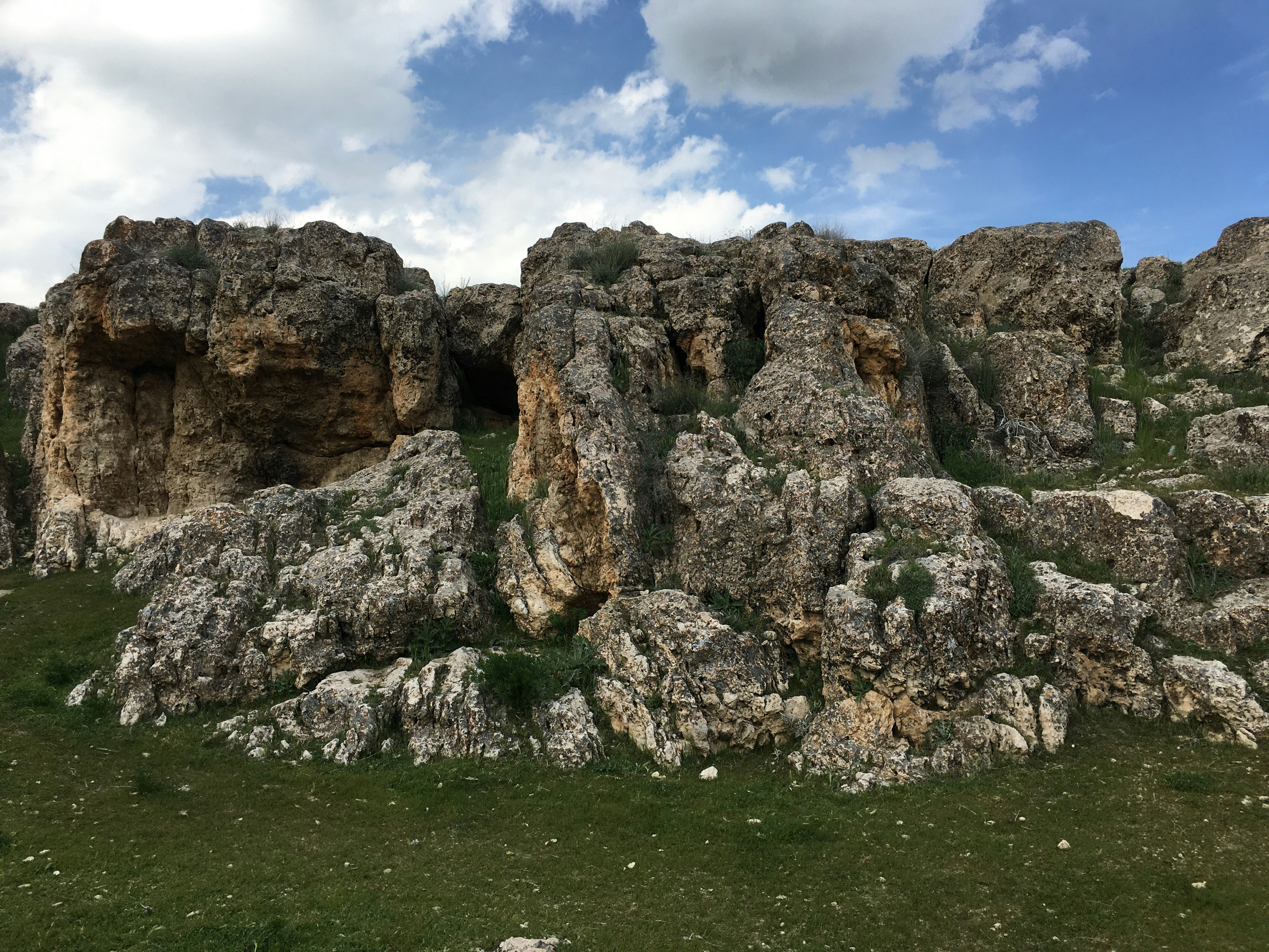 A rocky outcropping with grass and rocks photo – Free Rock Image on ...