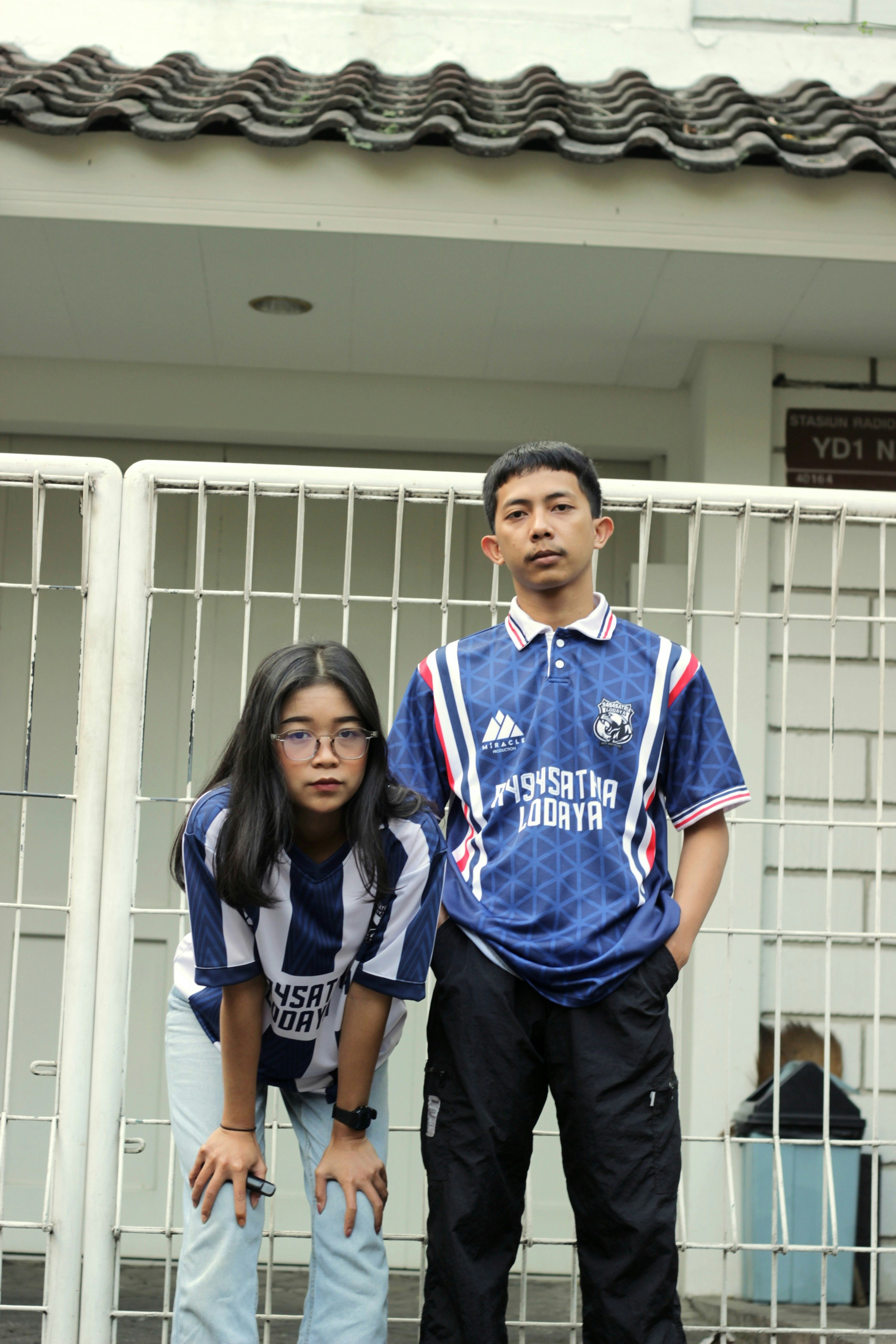 A man and a woman standing in front of a gate