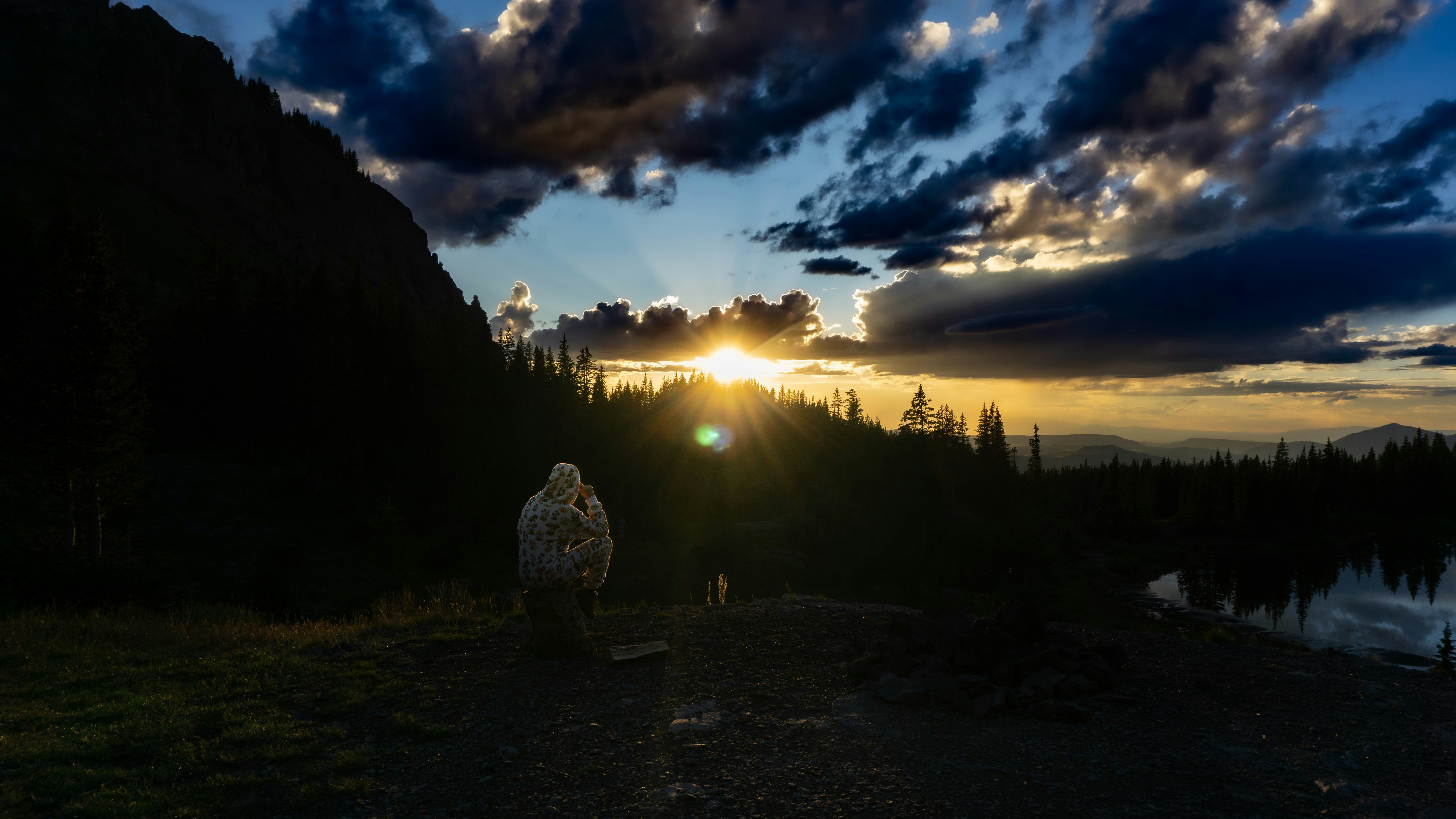 A person standing on a dirt road at sunset