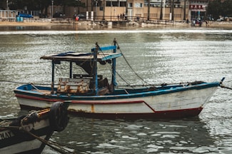 A small boat floating on top of a body of water