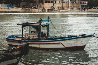 A small boat floating on top of a body of water
