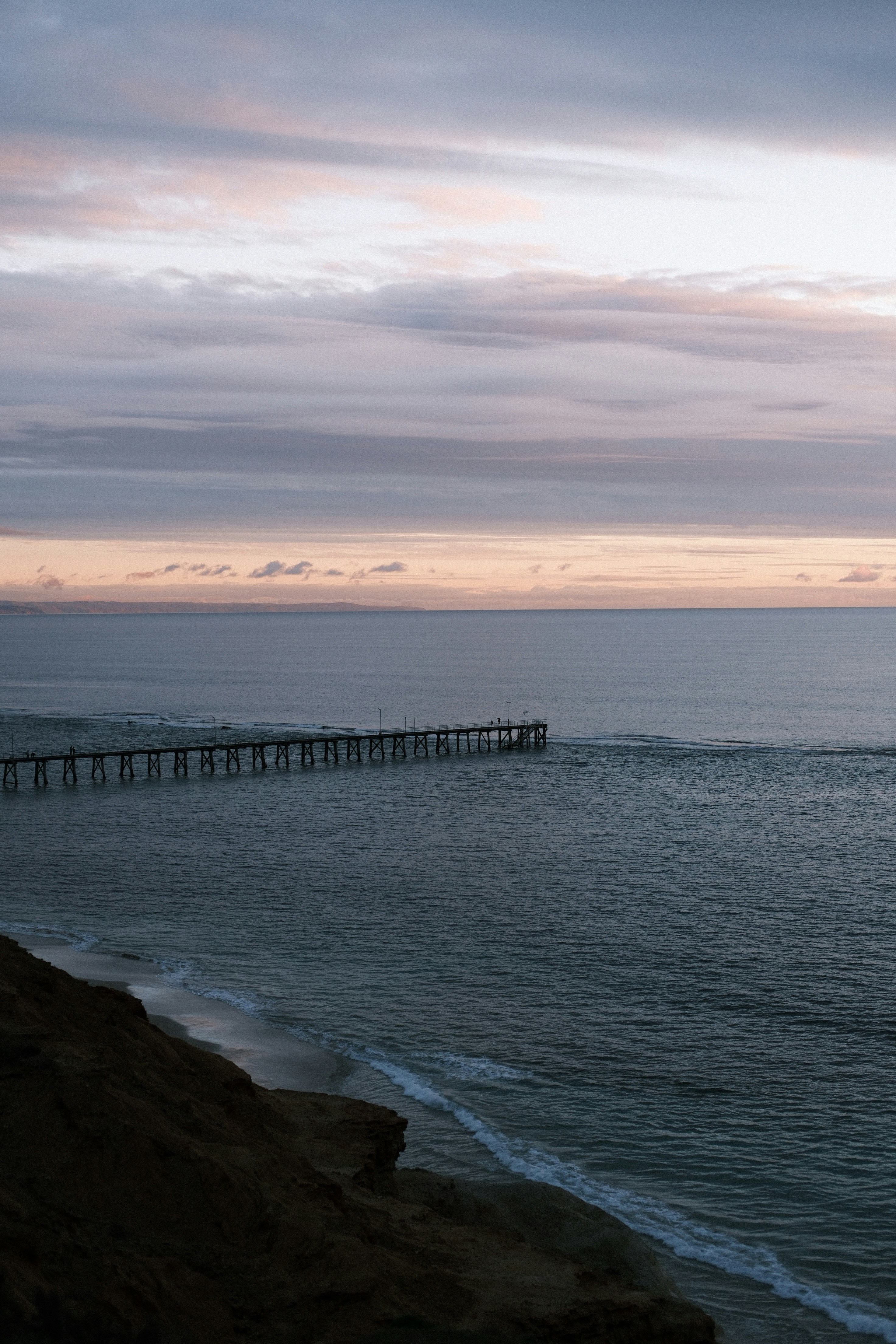A body of water with a long pier in the distance photo – Free Adelaide ...