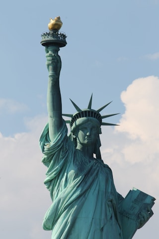The statue of liberty has a golden crown on top of it