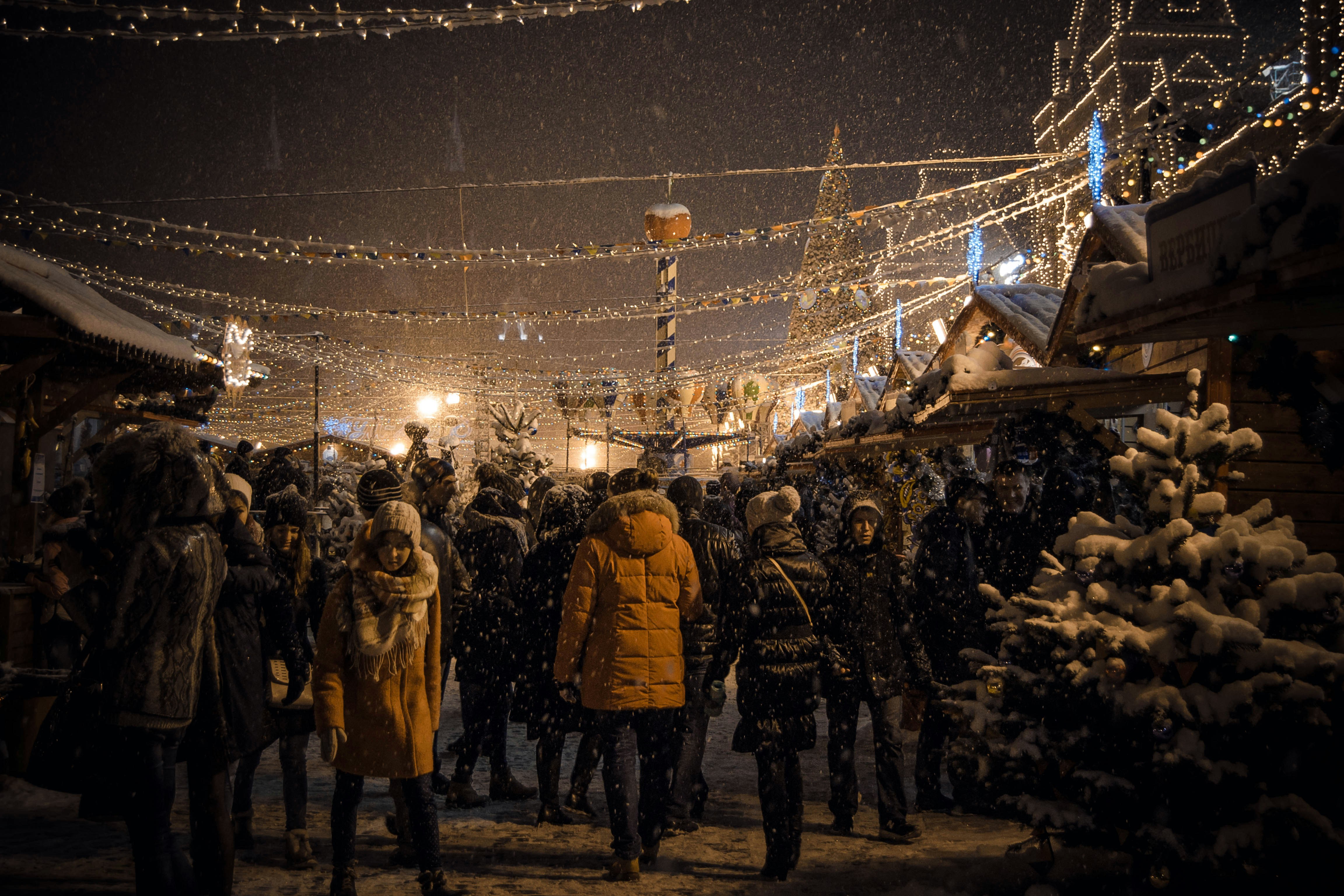 A crowd of people standing around a christmas tree photo – Free Urban ...