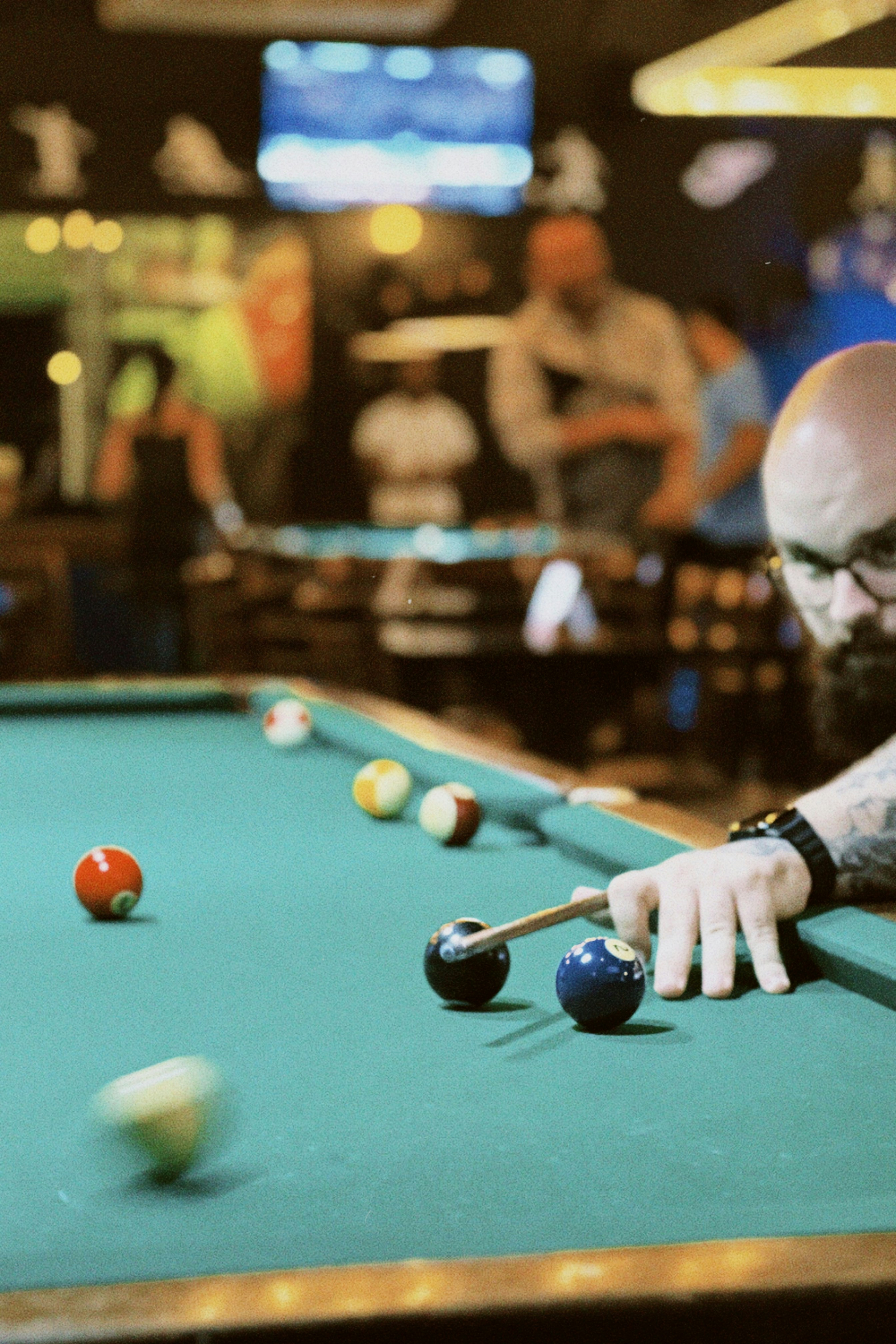 A man leaning over a pool table with a cue in his hand