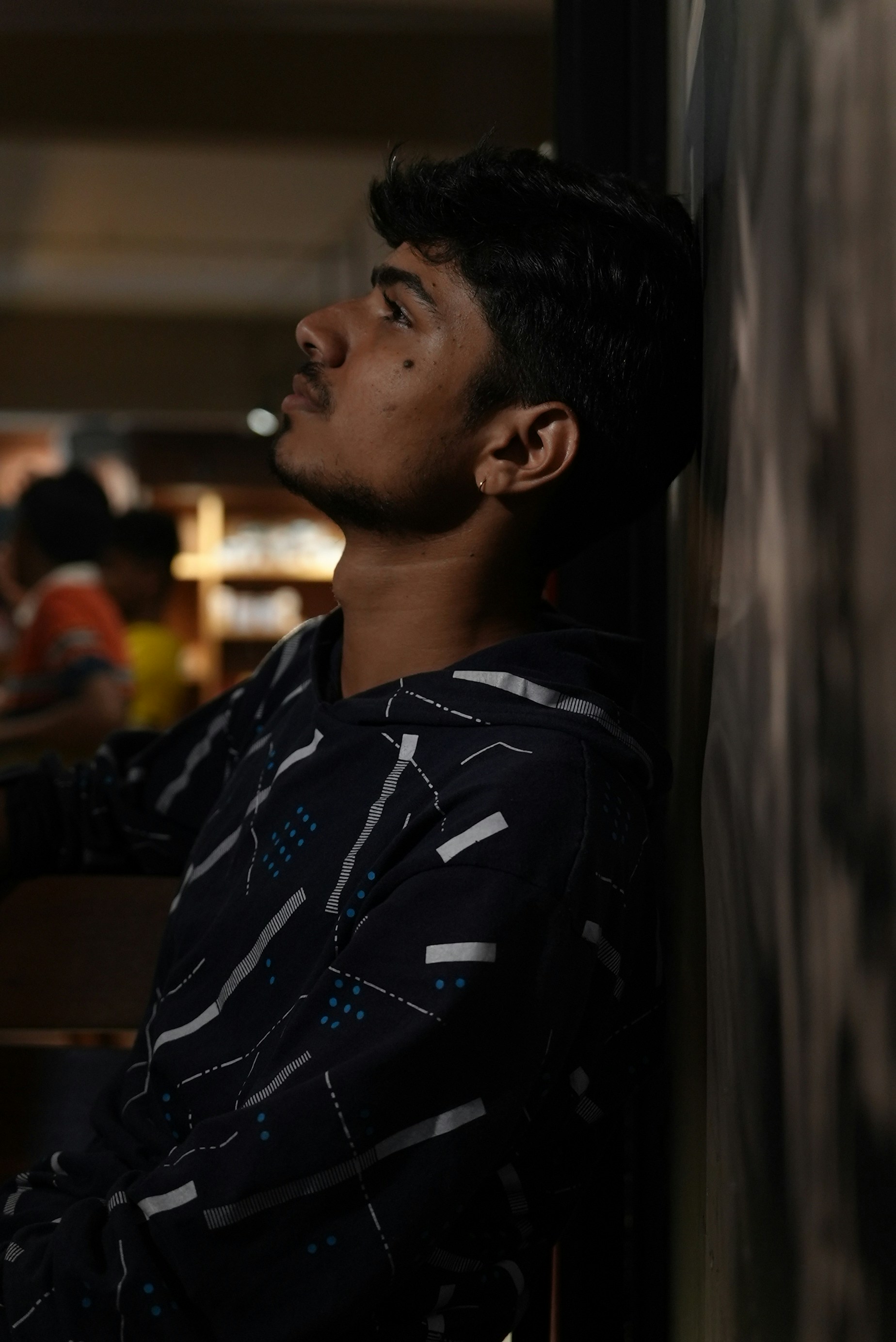 Un uomo appoggiato a un muro in un ristorante