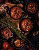 A table topped with bowls of soup and vegetables