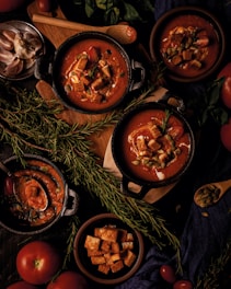A table topped with bowls of soup and vegetables