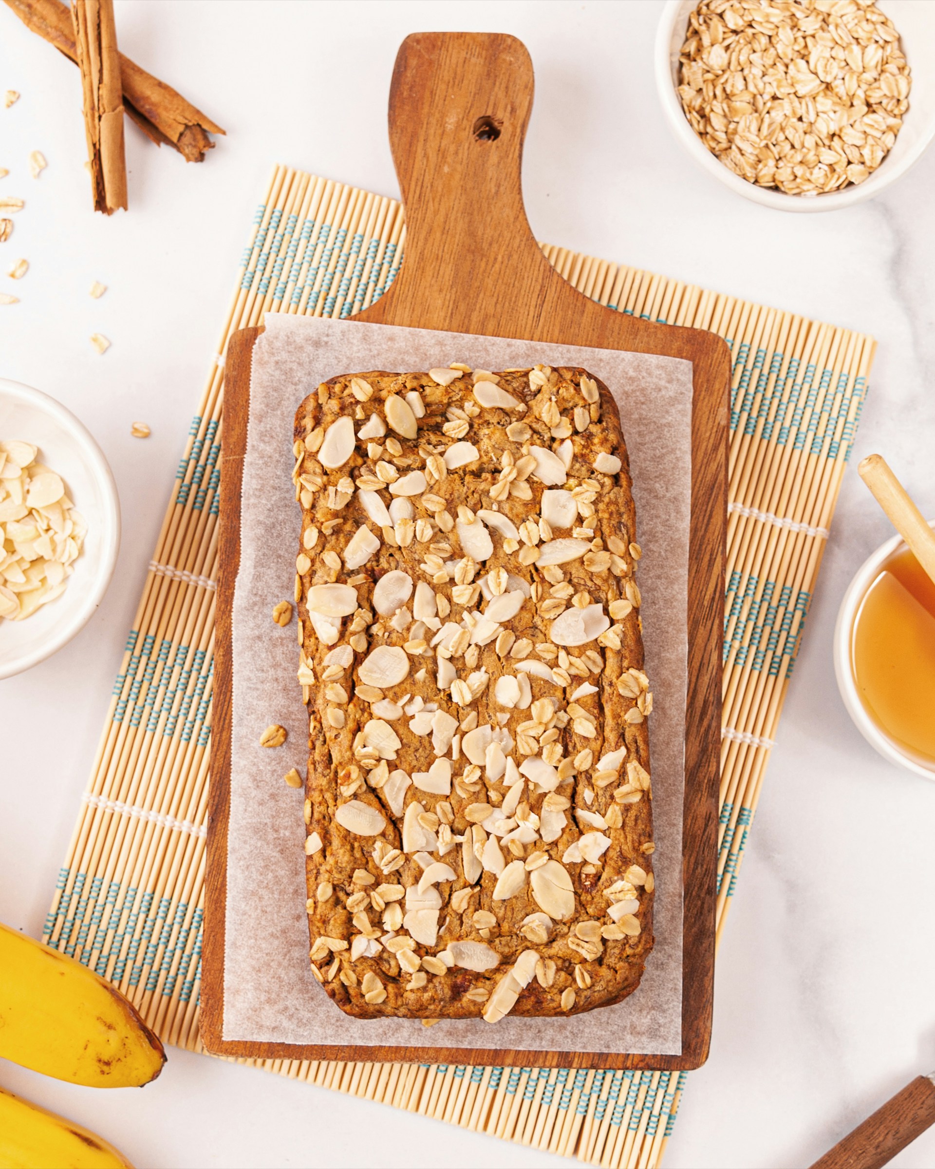 A loaf of oatmeal sitting on top of a cutting board next to