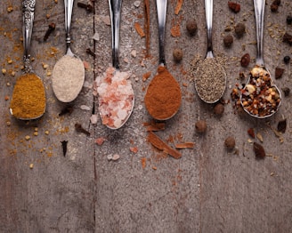 Spoons filled with different types of food on a table
