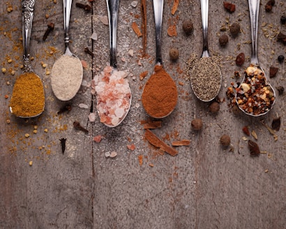 Spoons filled with different types of food on a table