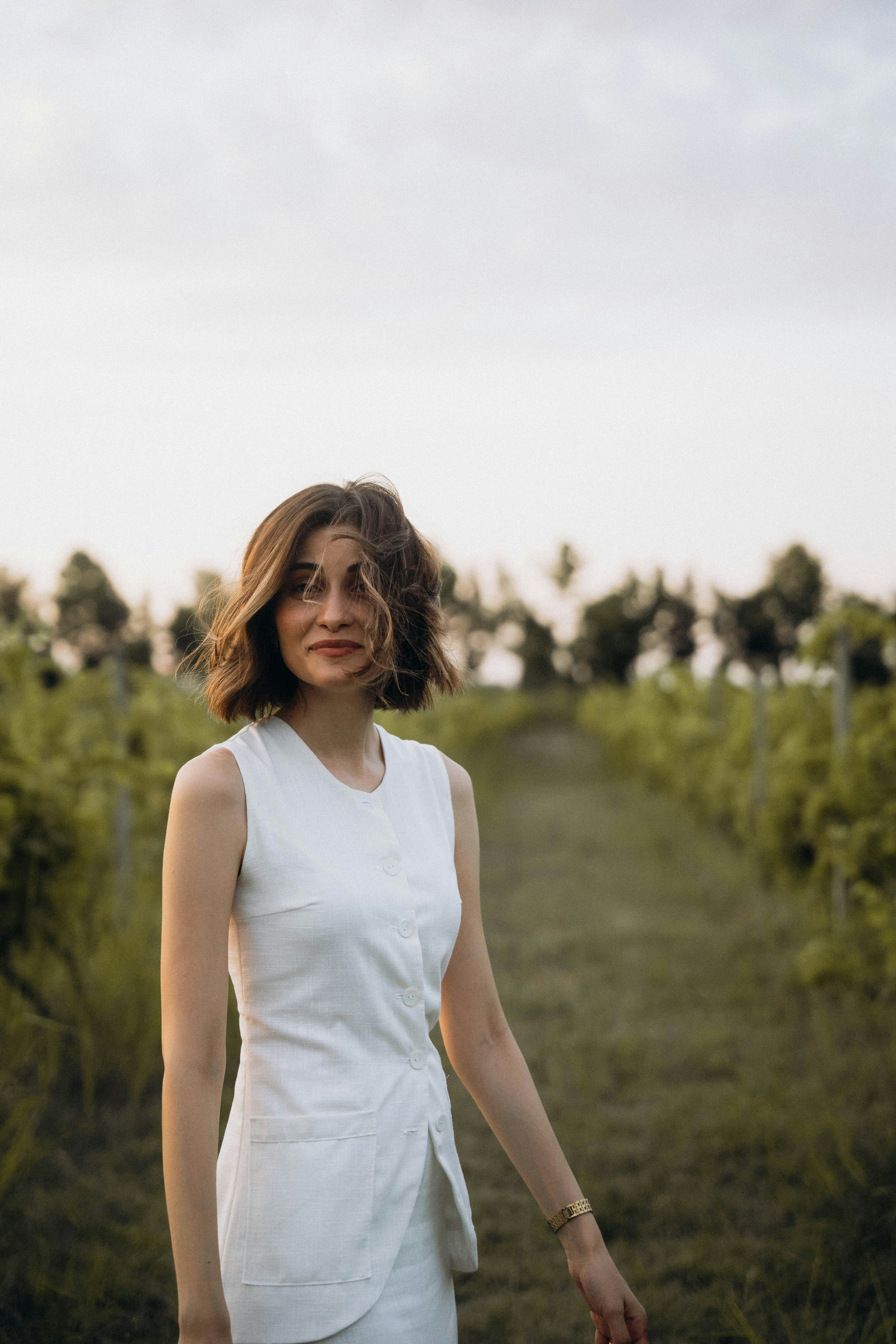 A woman in a white dress standing in a field