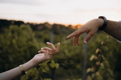 Two people reaching out their hands to touch each other