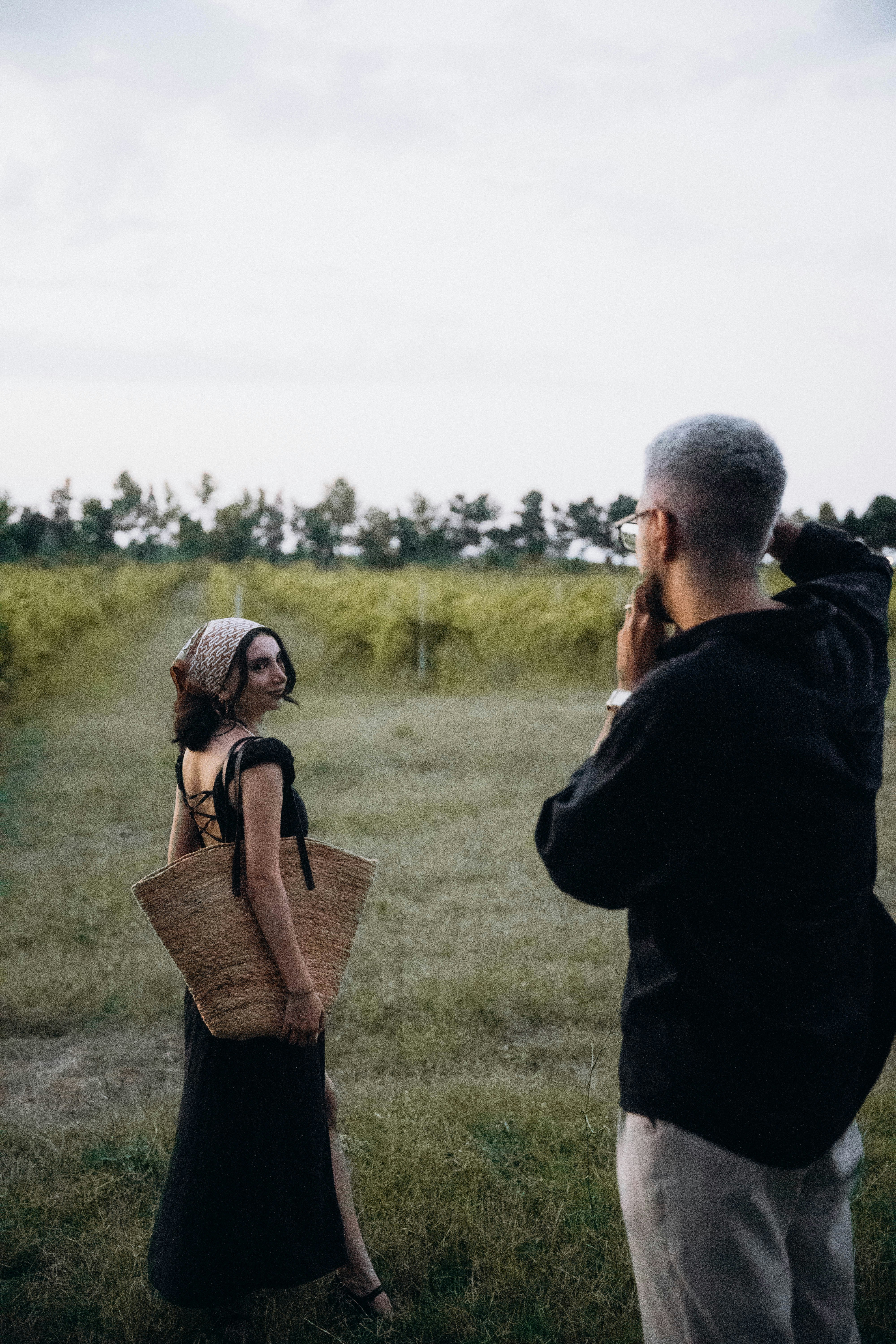 A man taking a picture of a woman in a field