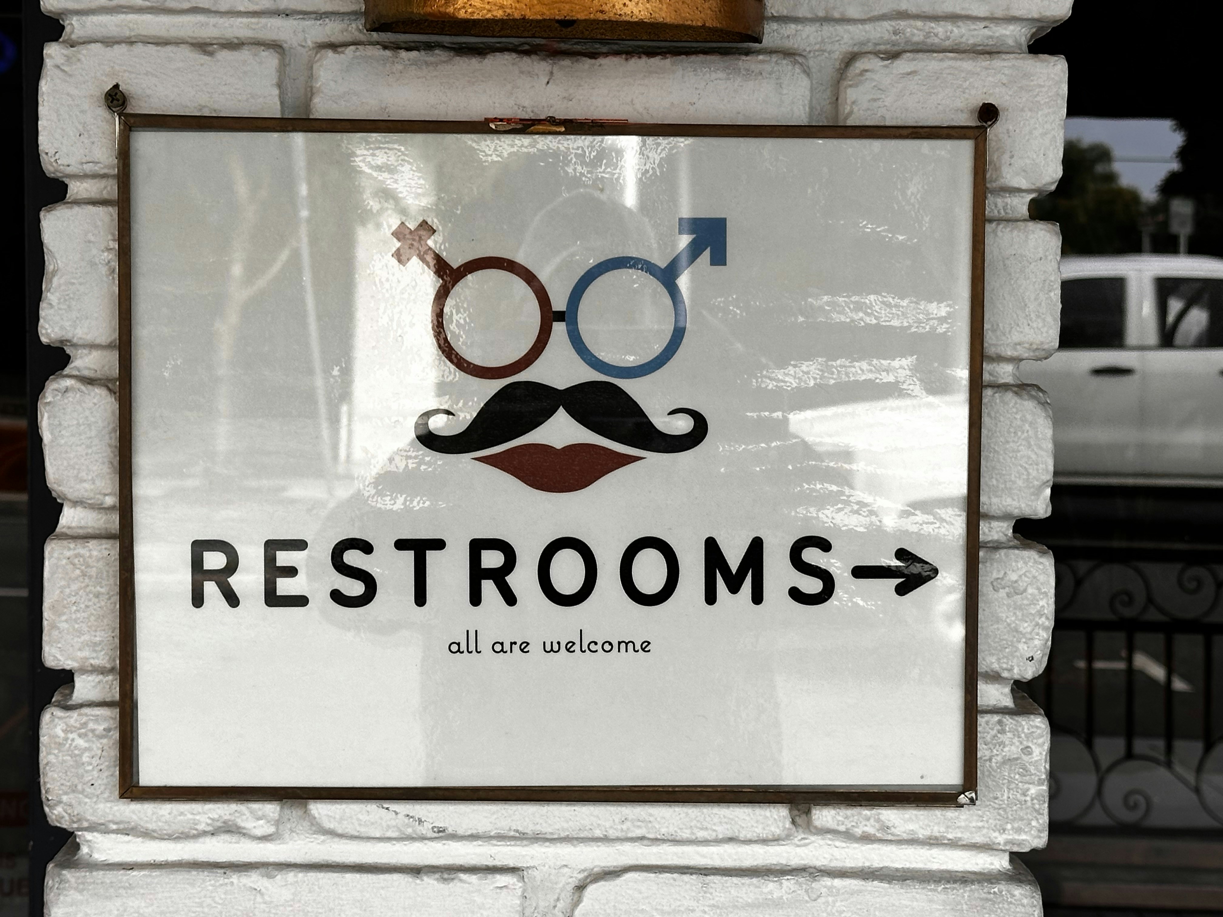 A sign that says restrooms with a mustache on it