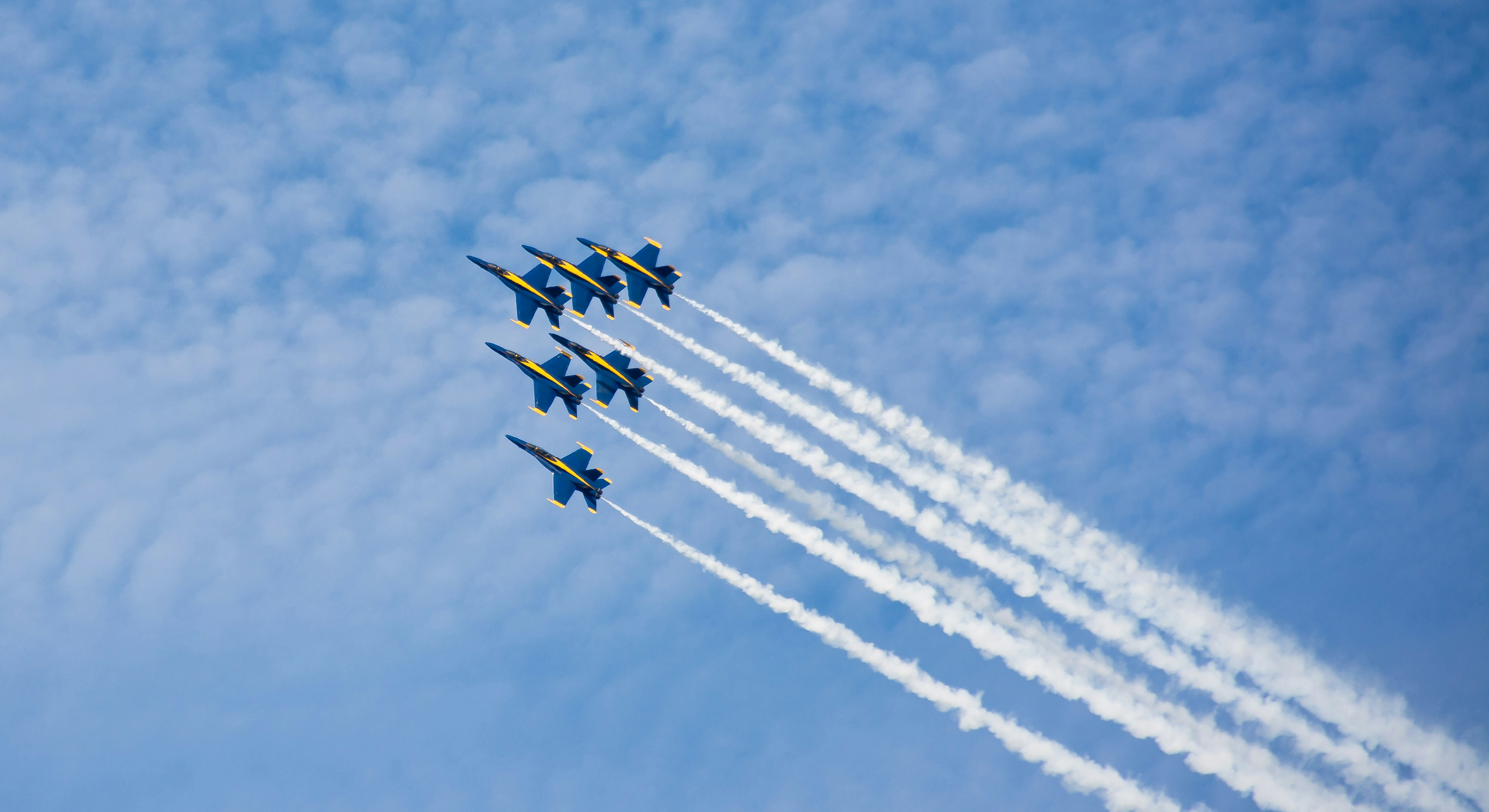 A group of fighter jets flying through a blue sky