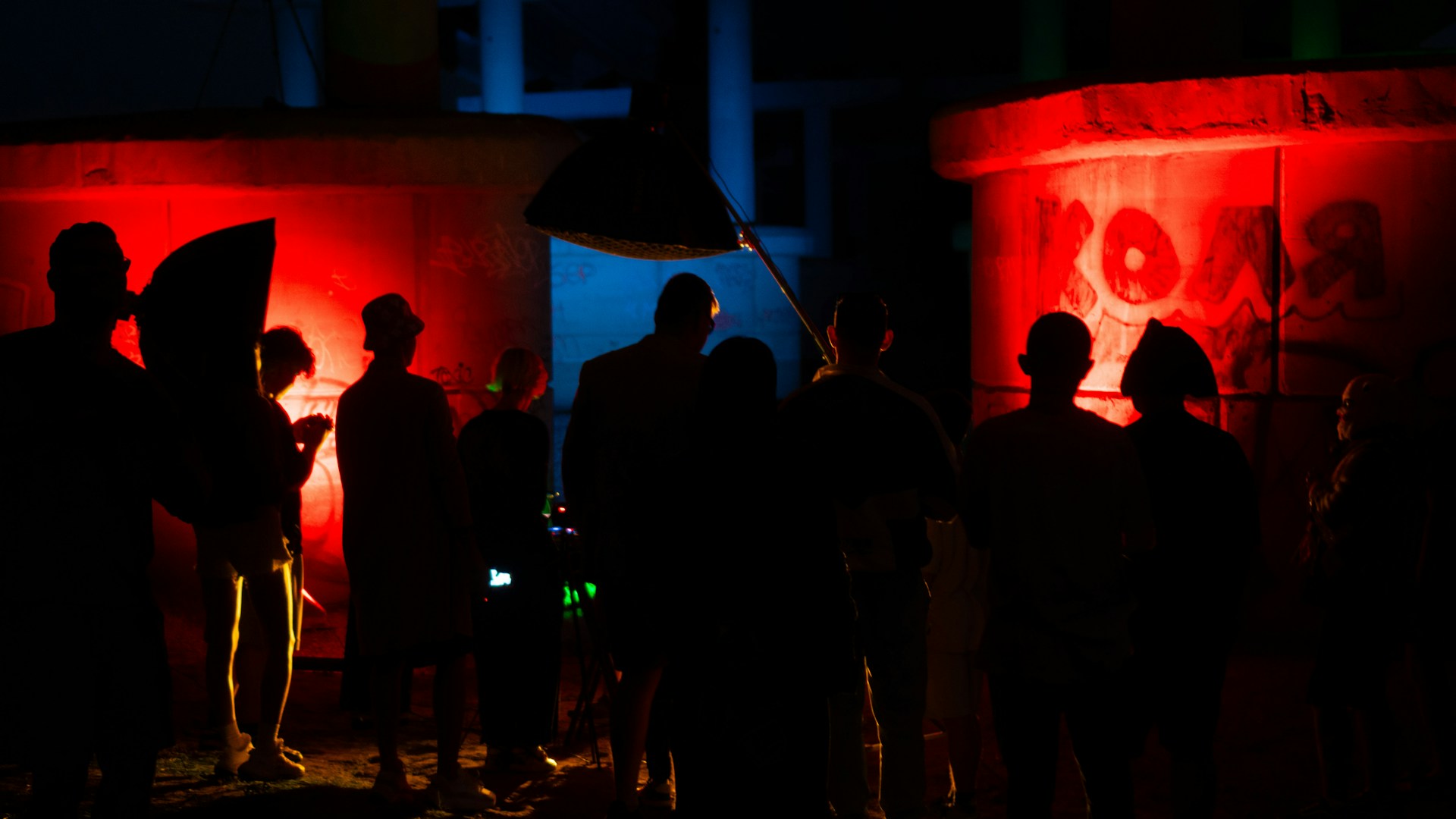 A group of people standing in front of red lights