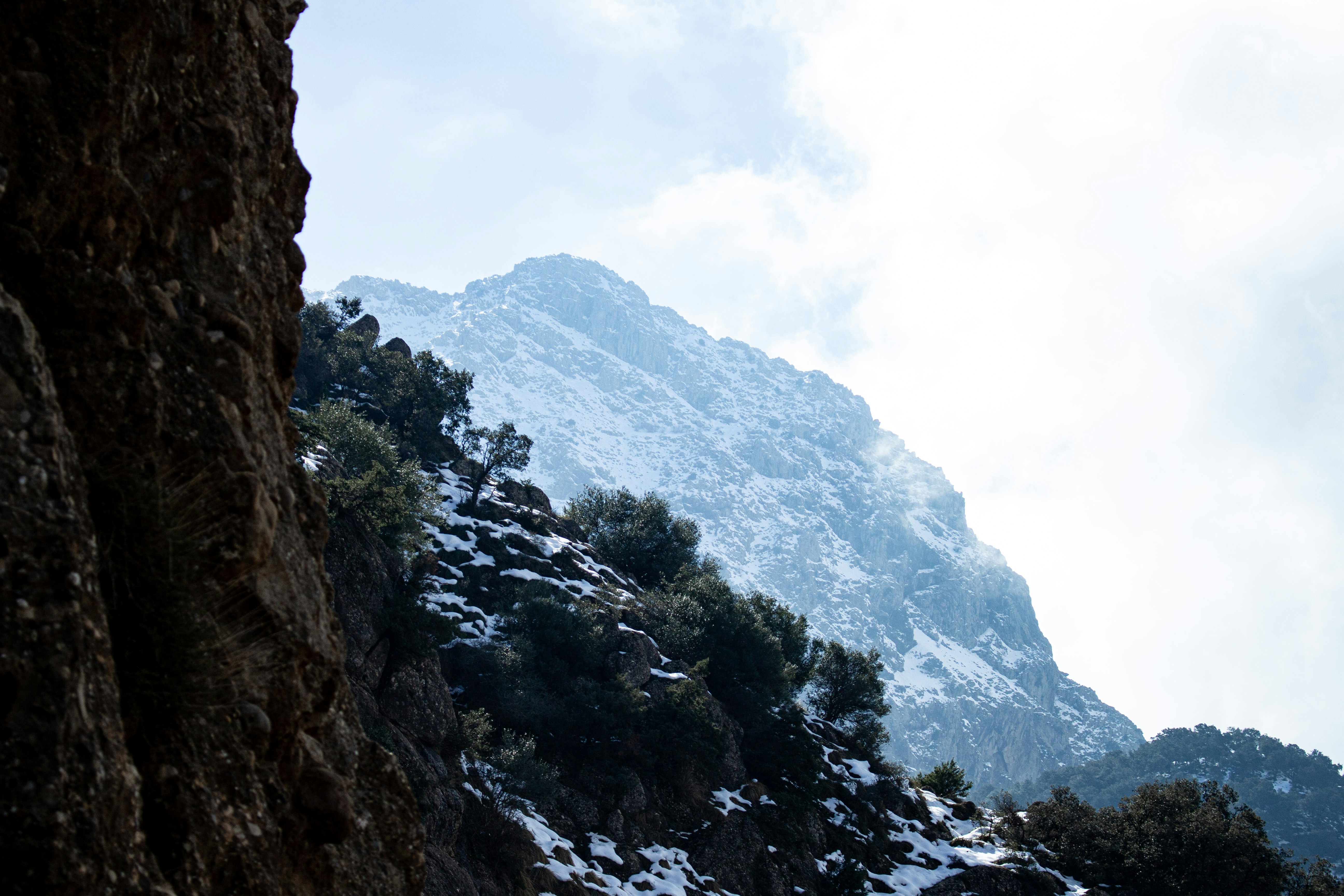 A mountain covered in snow with a sky background