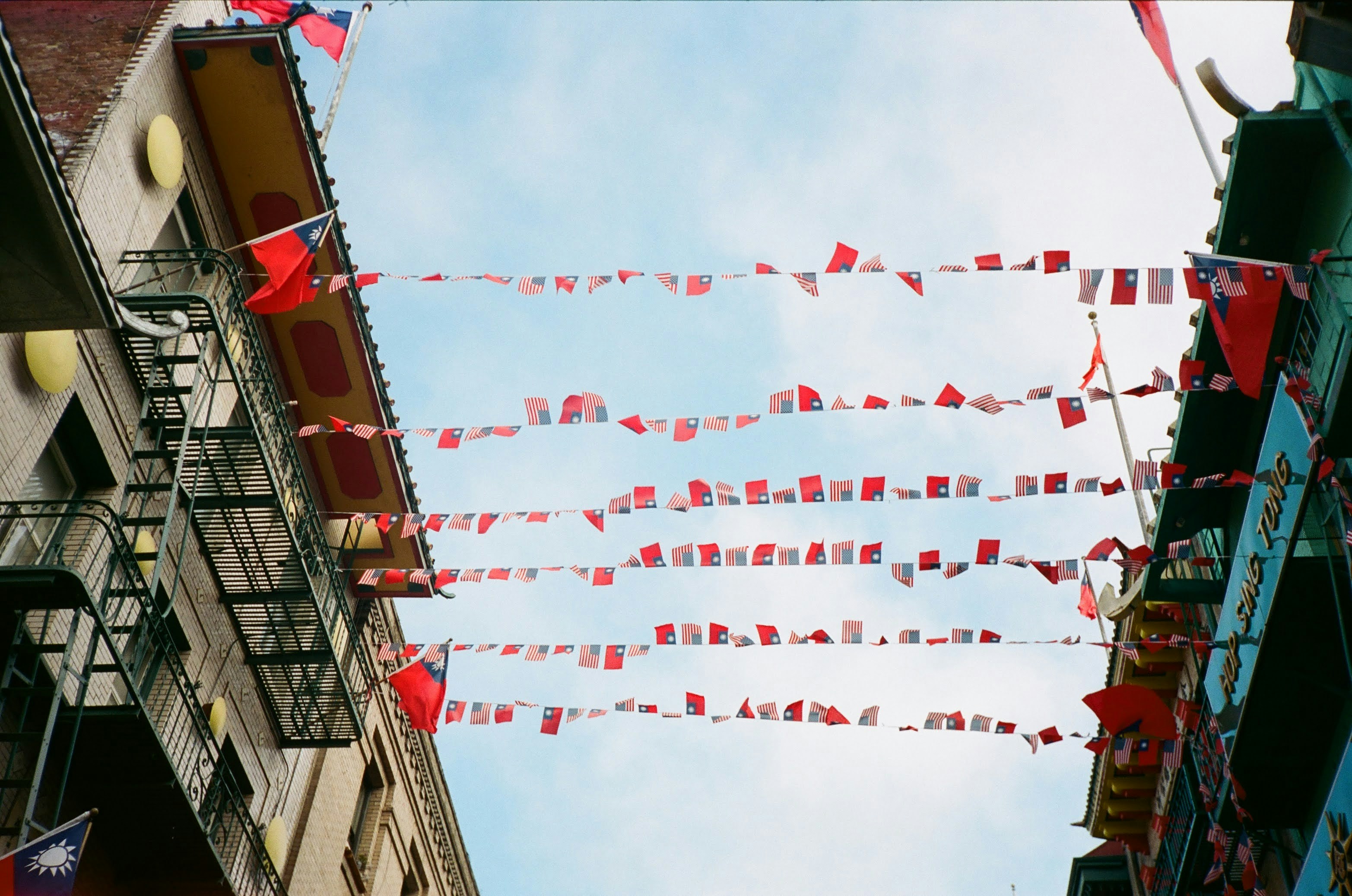 A group of red flags hanging from the side of a building