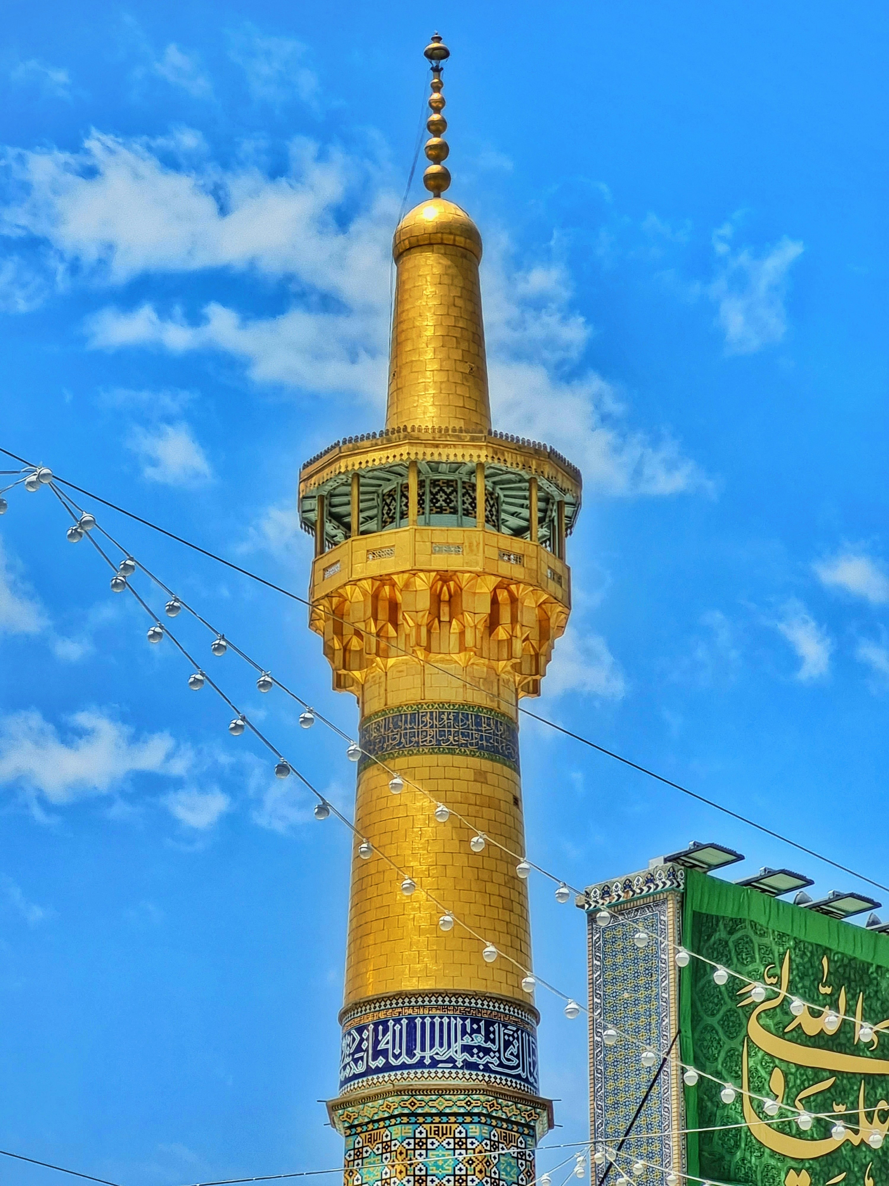 A tall golden tower with a sky background