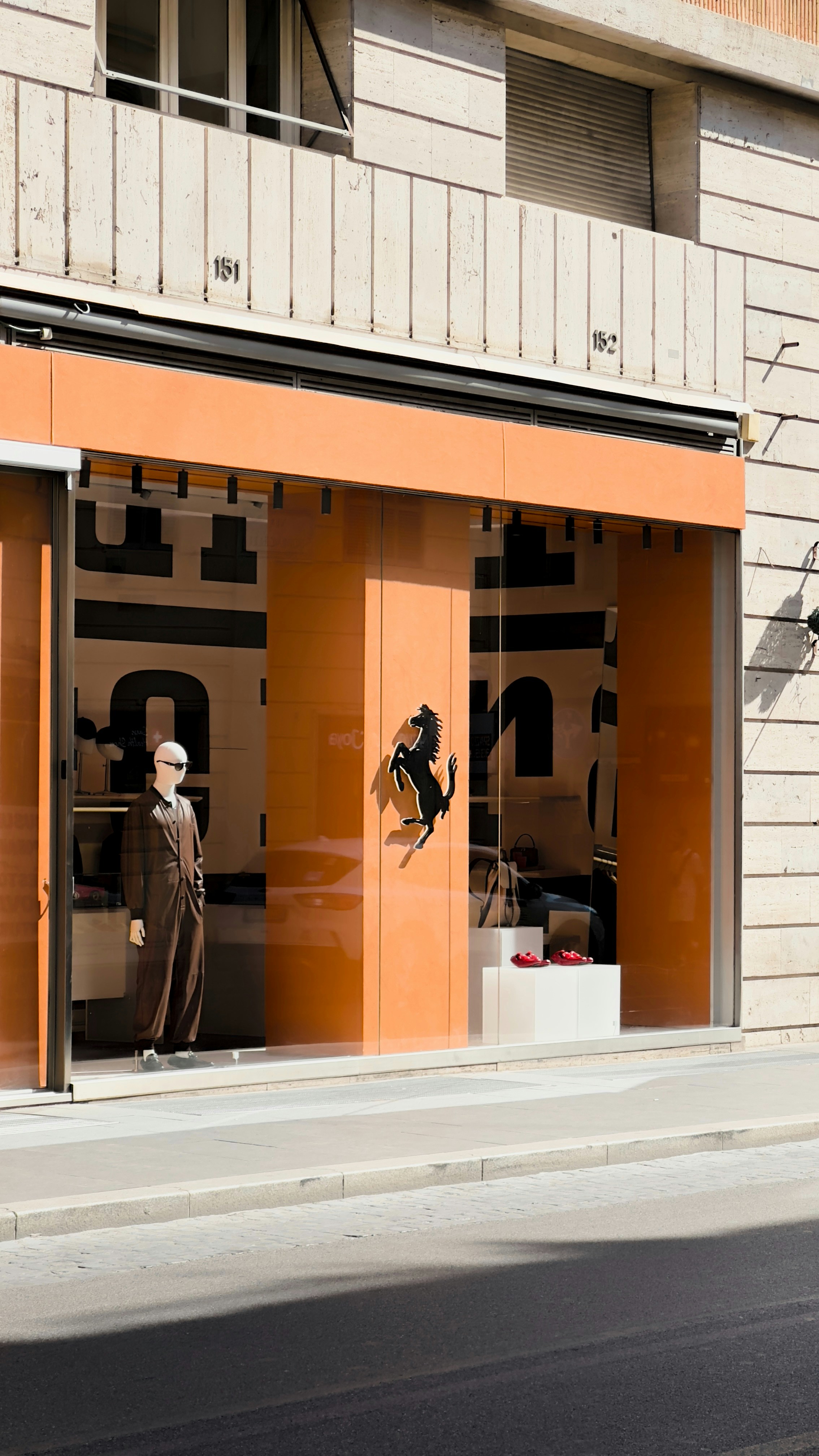 An orange store front with mannequins in the window
