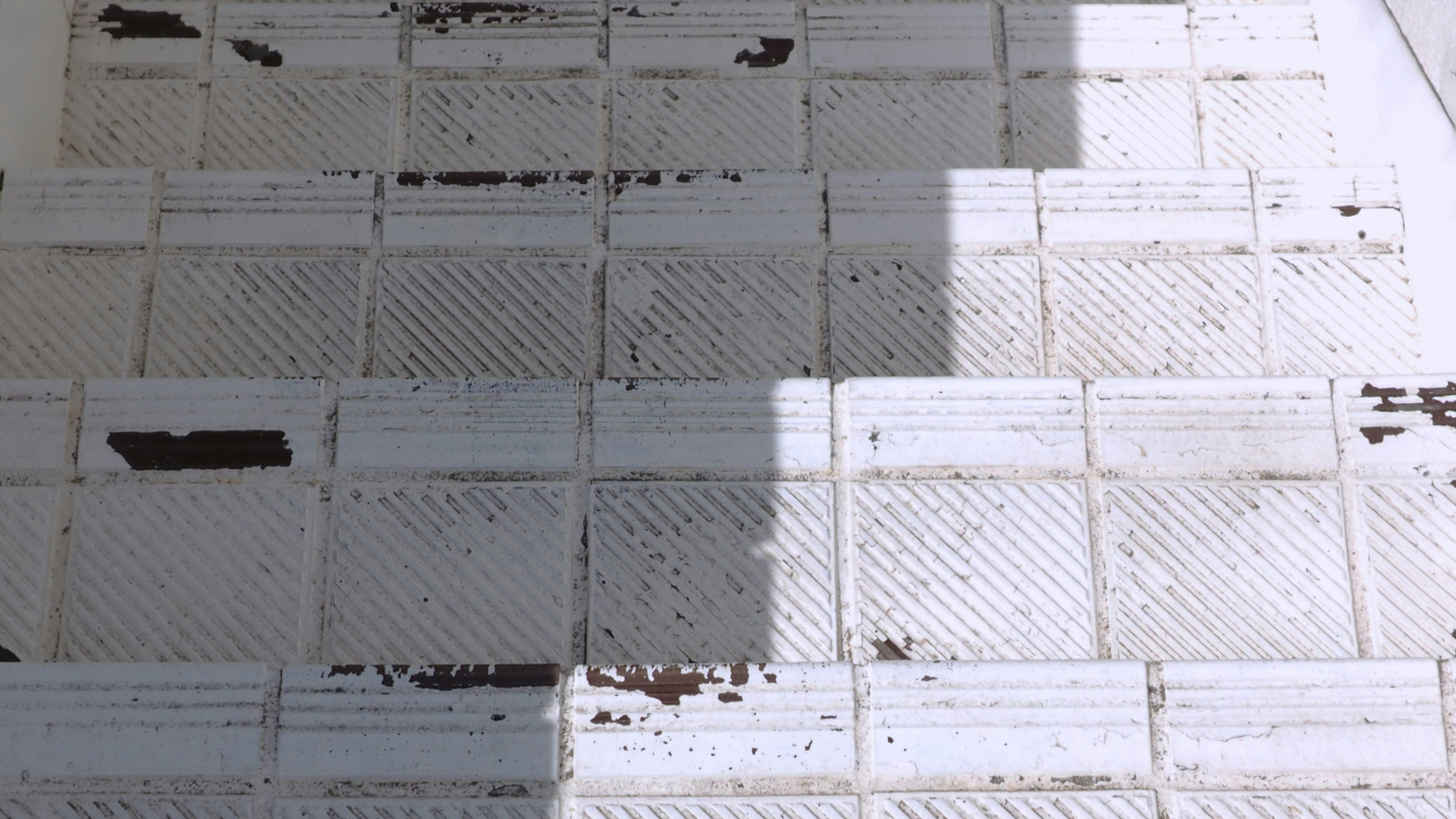 A close up of a tiled floor with a skateboard on it