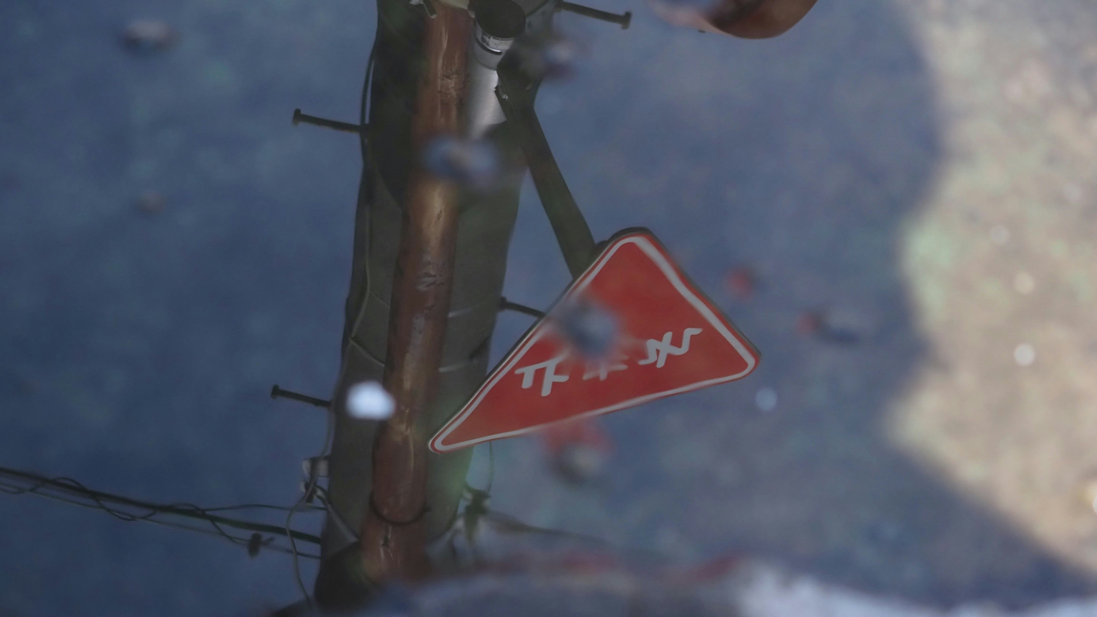 A street sign is reflected in a puddle of water