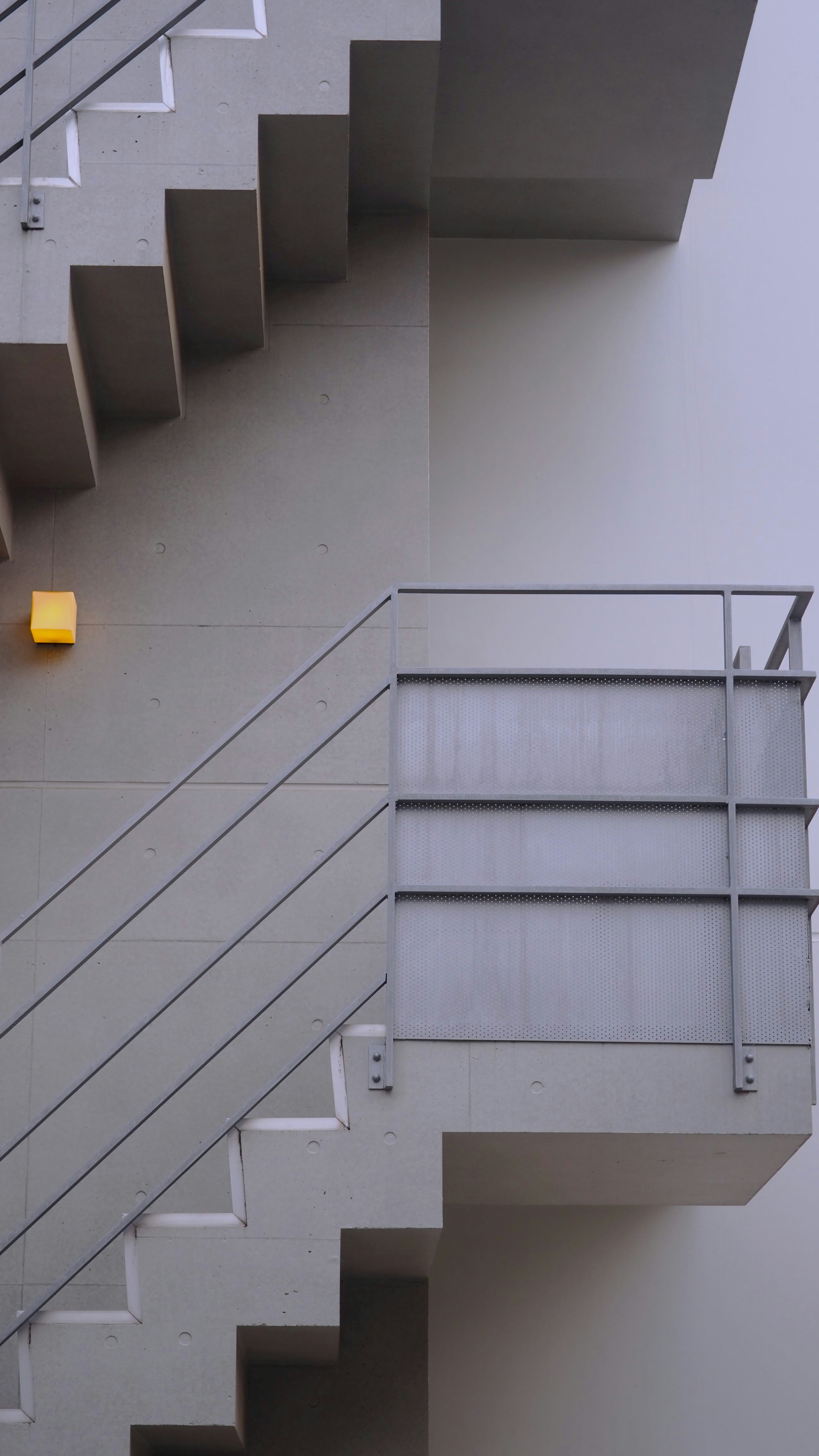 A yellow light is on the side of a building