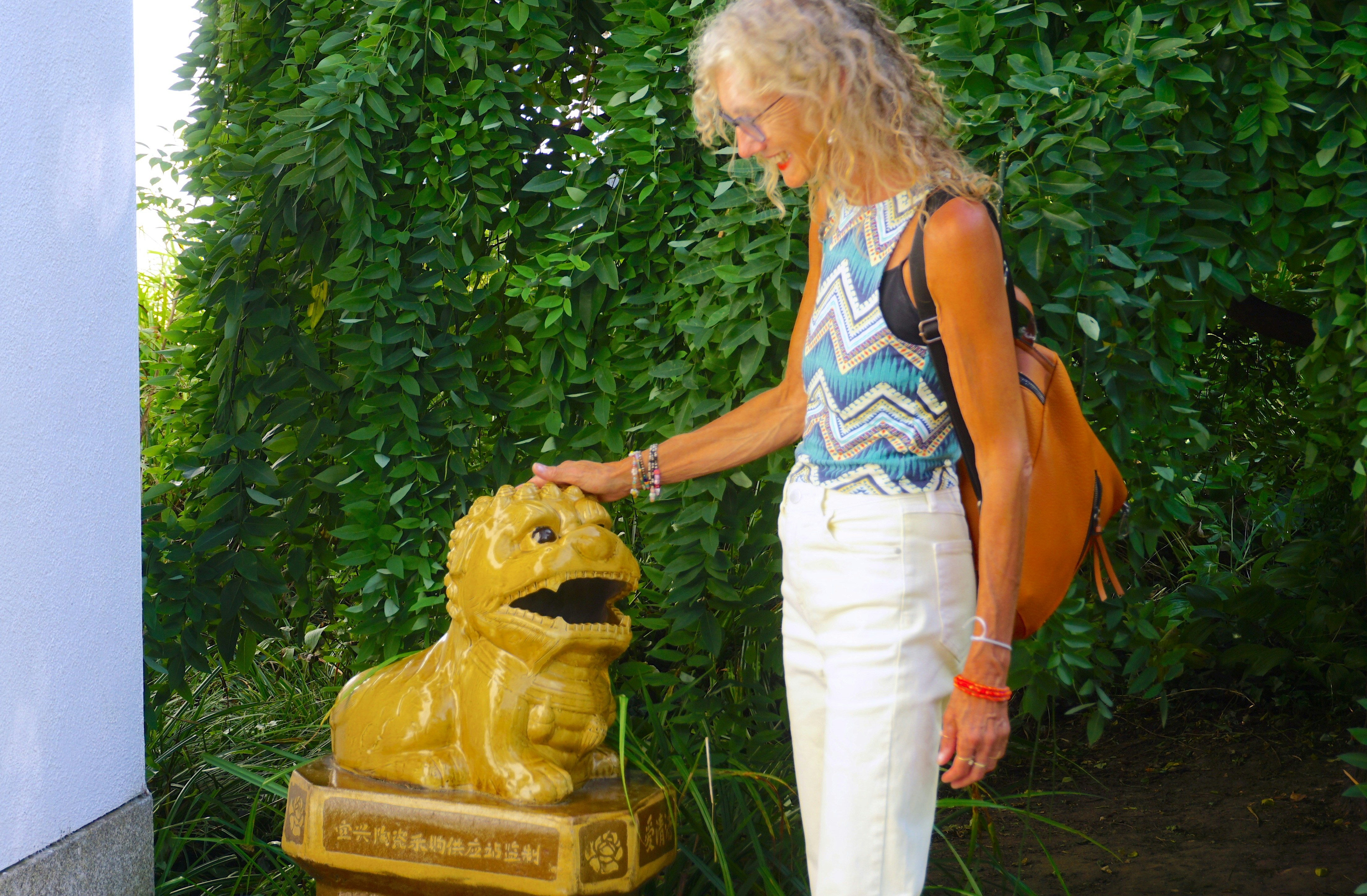 A woman standing next to a statue of a lion