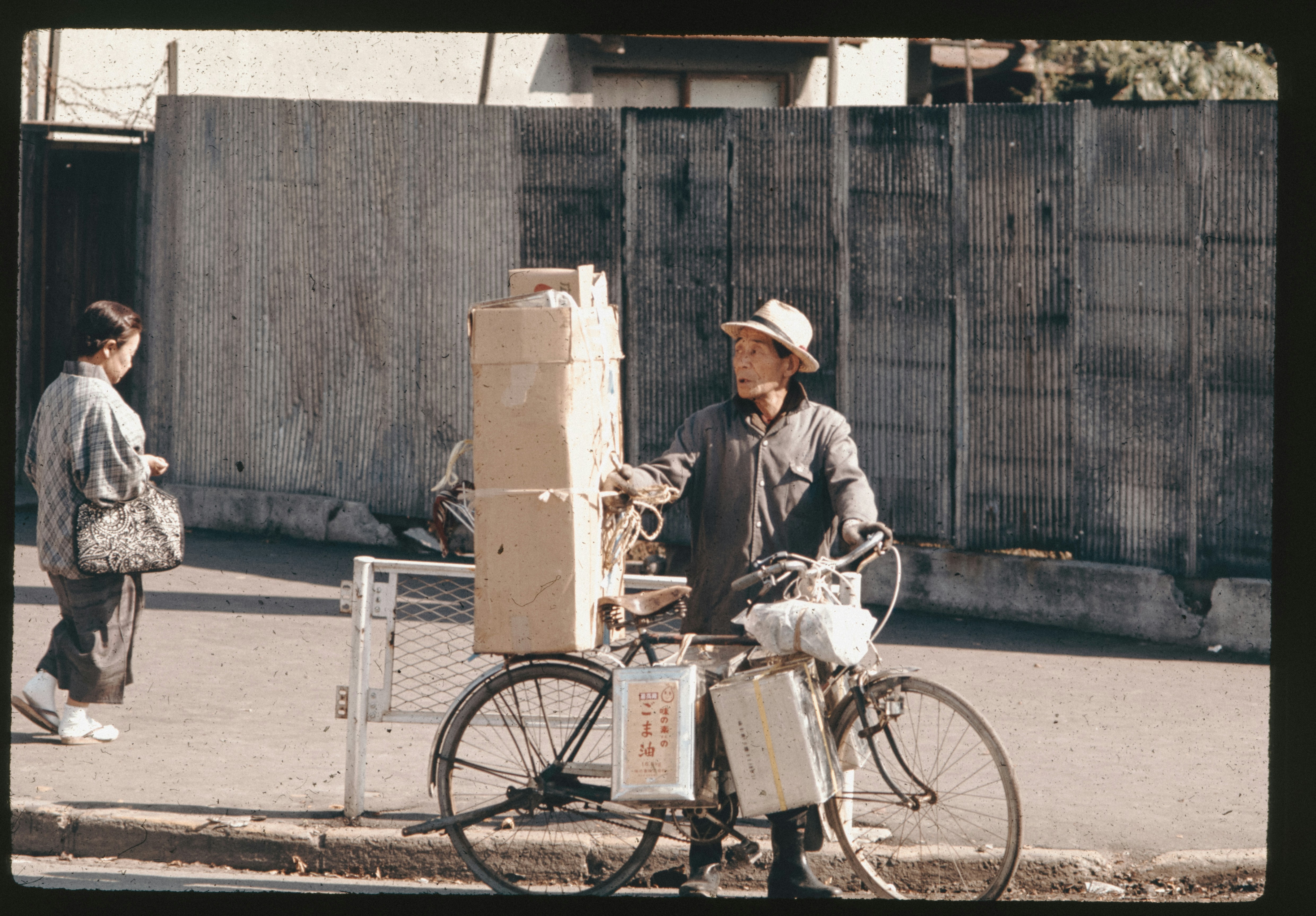 A man standing next to a bike on a street