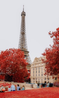 A group of people sitting on a bench in front of the eiffel tower