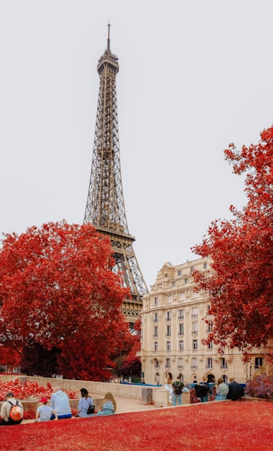 A group of people sitting on a bench in front of the eiffel tower