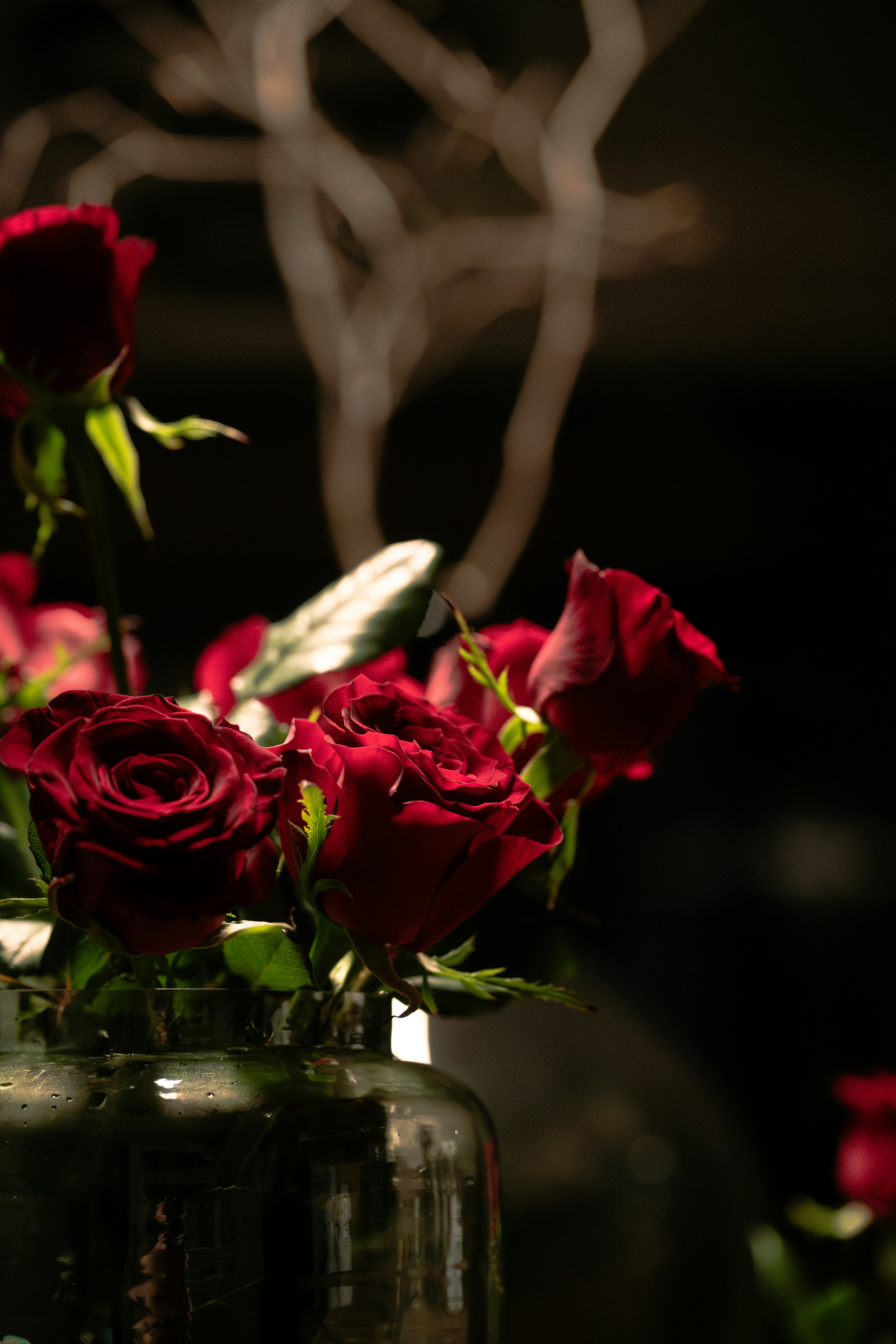 Un jarrón lleno de rosas rojas encima de una mesa
