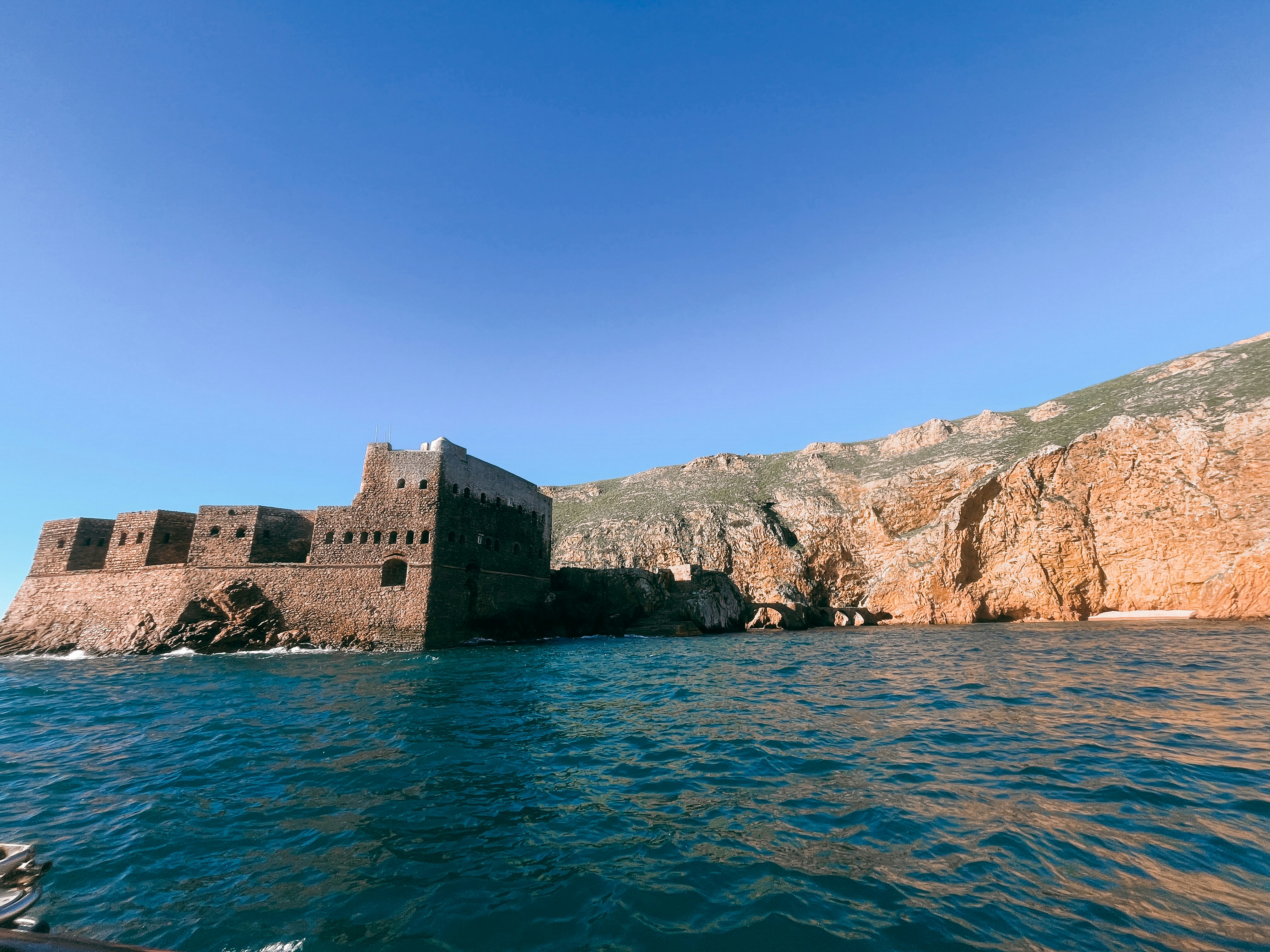 A large stone building sitting on top of a body of water