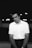 A man standing in front of a wall with his hands in his pockets