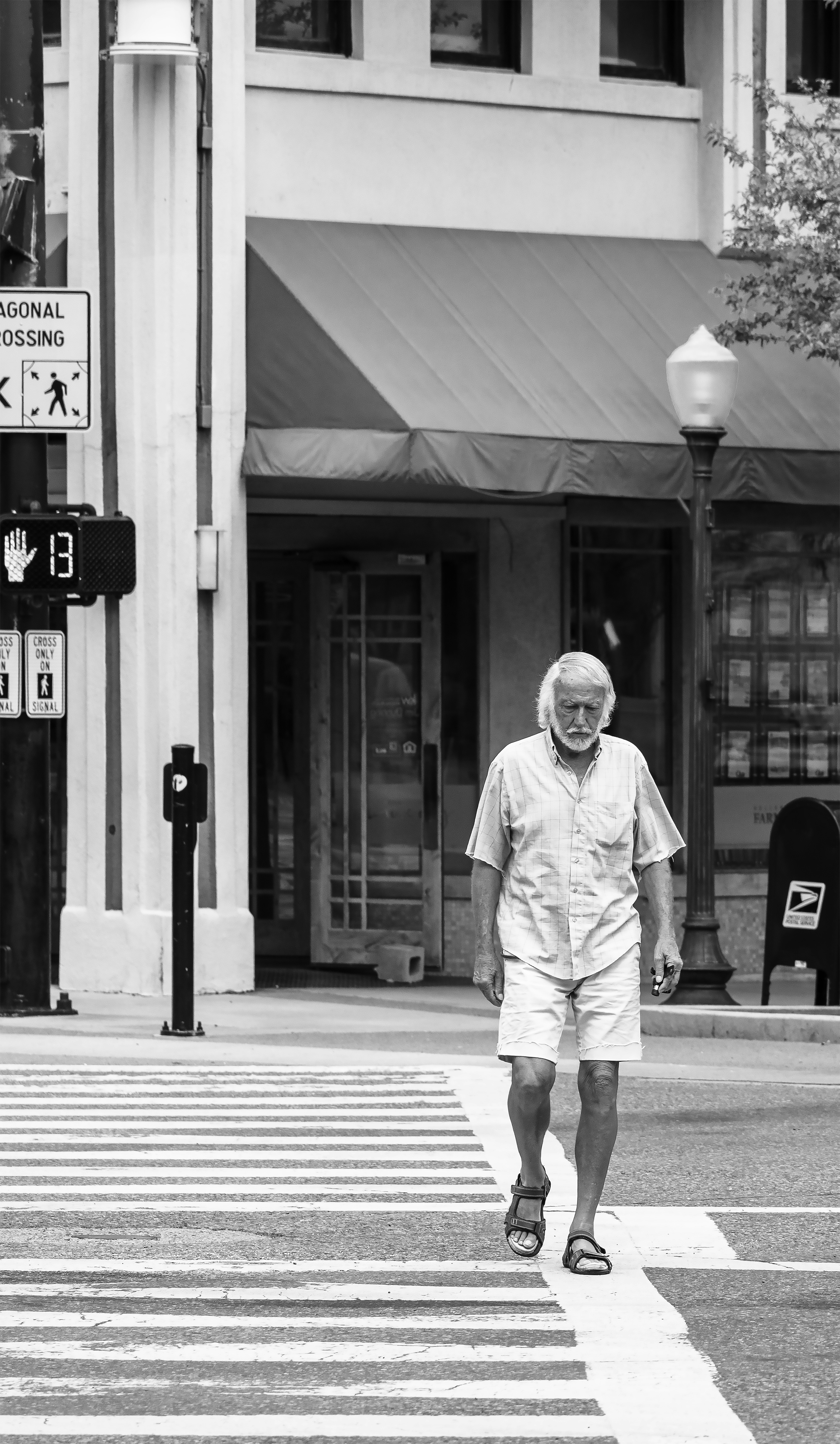 A man walking across a street next to a crosswalk