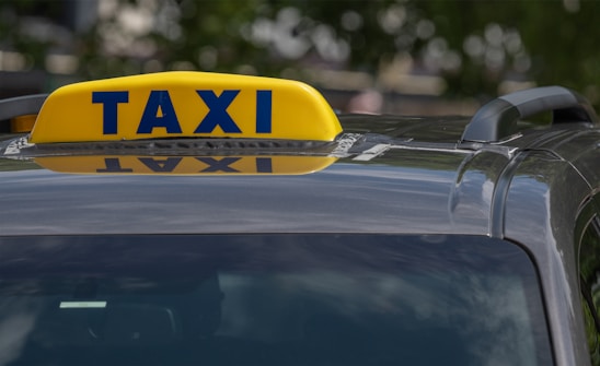 A taxi cab with a yellow taxi sign on top of it