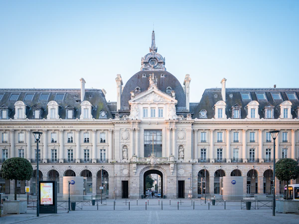 Un grand bâtiment avec une tour d’horloge devant lui