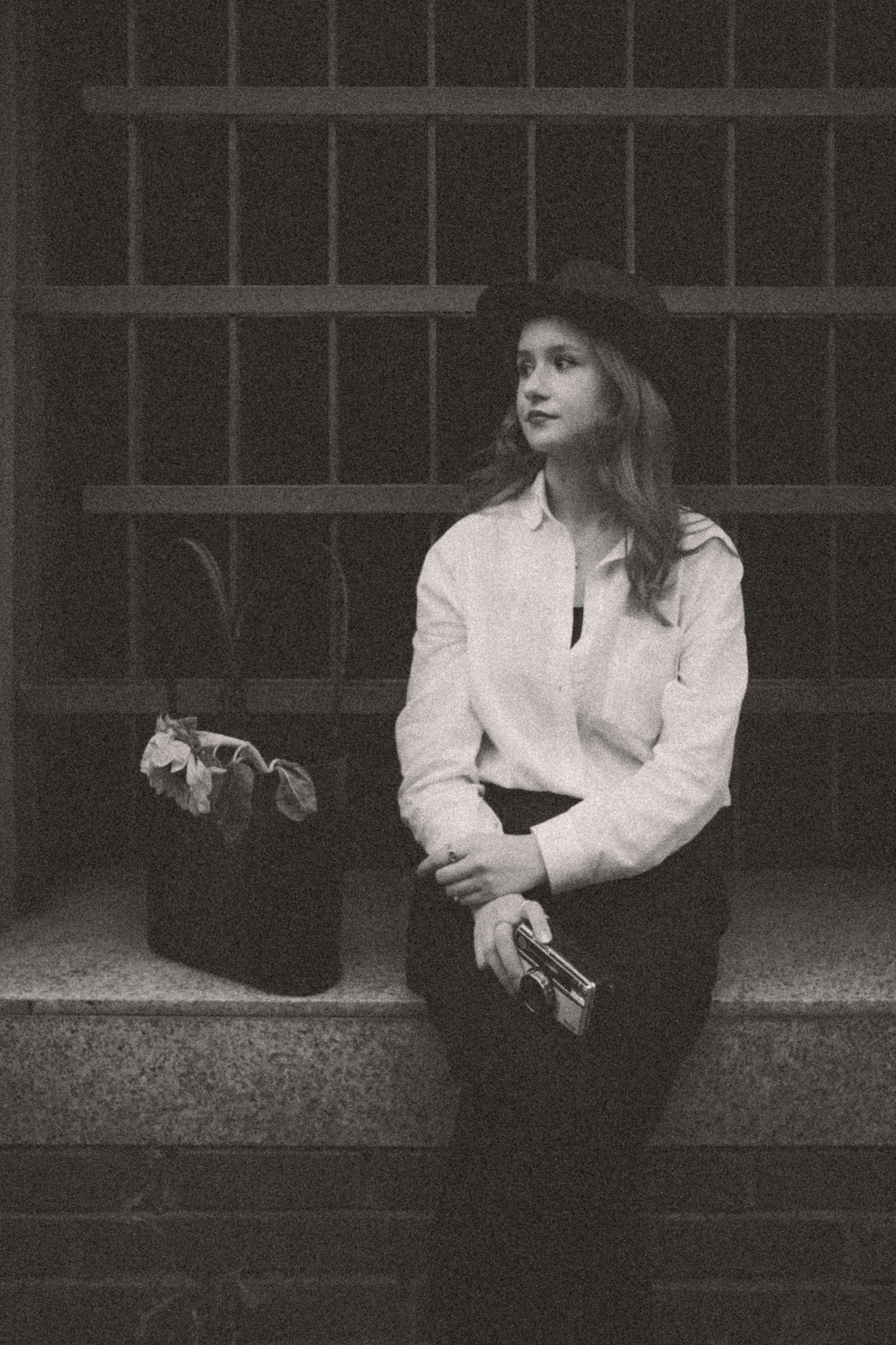 A black and white photo of a woman sitting on steps