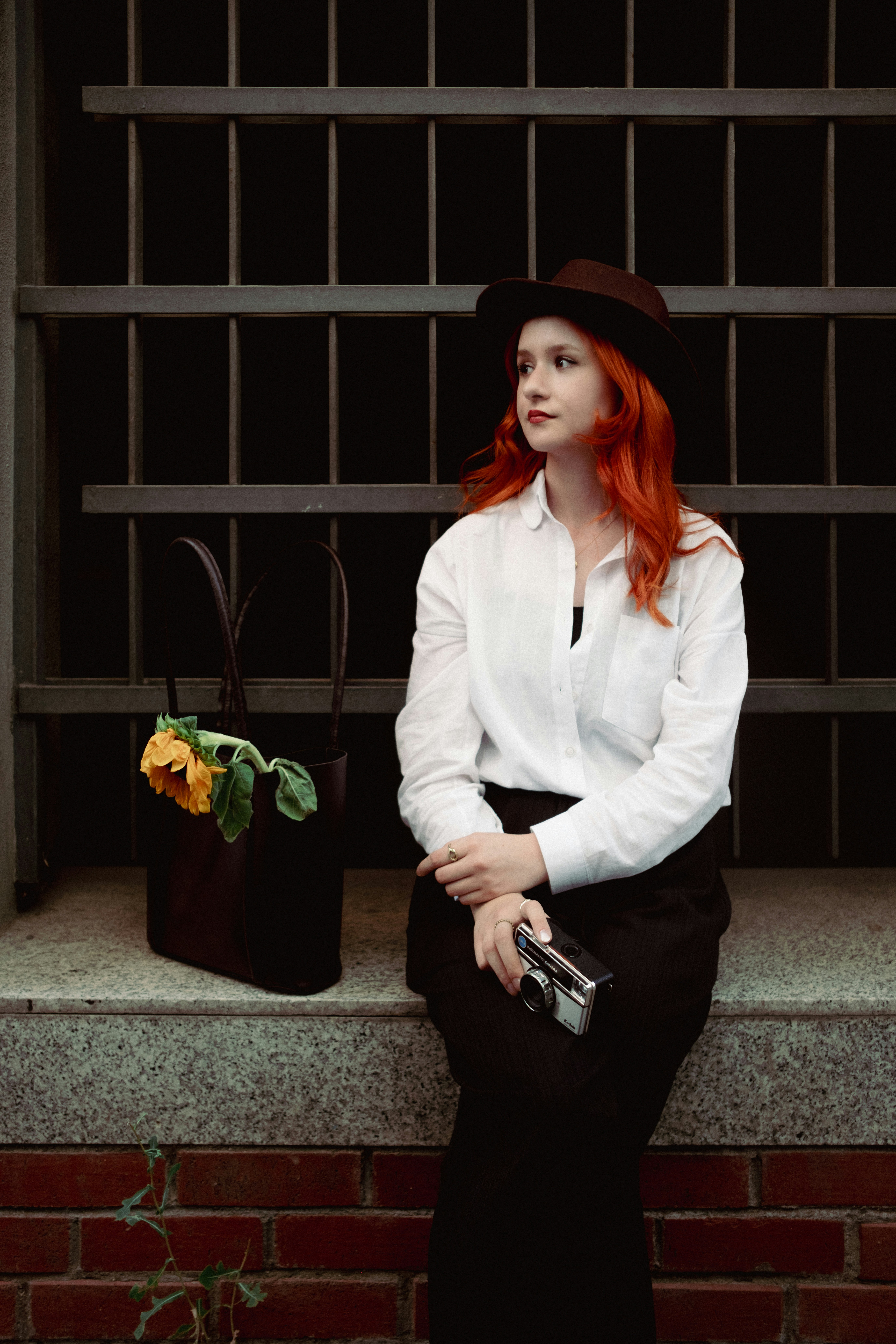 A woman with red hair sitting on a step