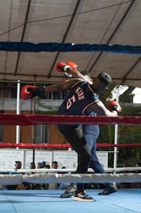A man standing in a boxing ring holding a red boxing glove